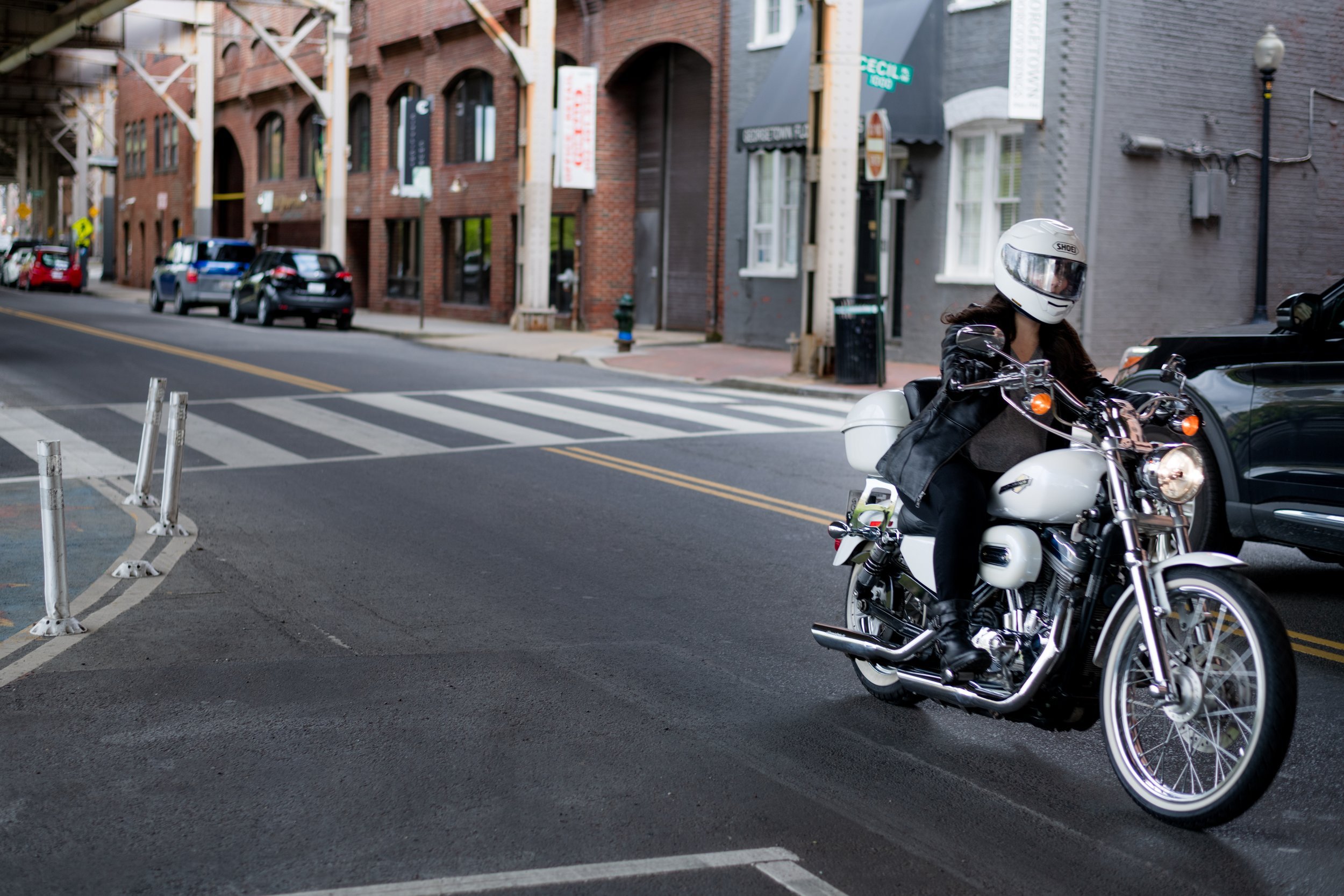A young, cheerful woman putting on a motorcycle helmet