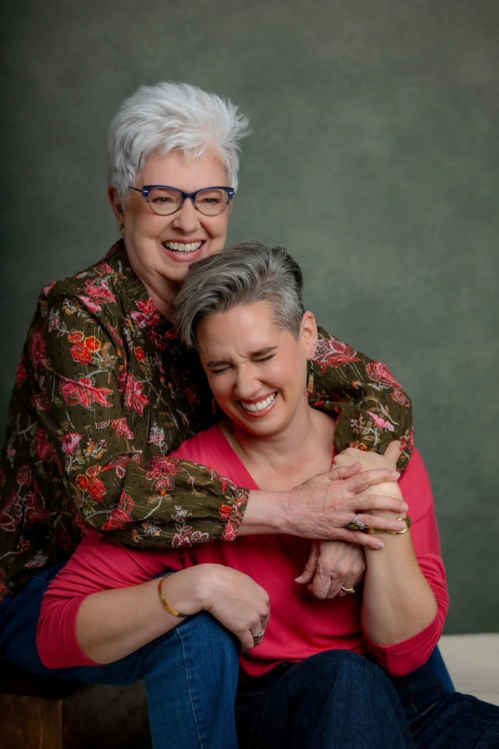 Mother and daughter happily embracing during a studio portrait session