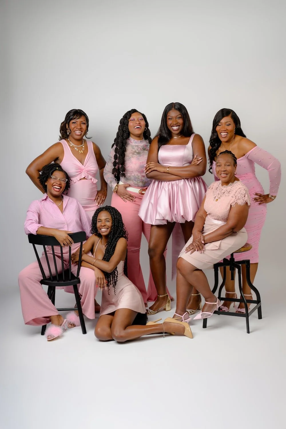 Group of women wearing coordinated pink outfits for a studio portrait