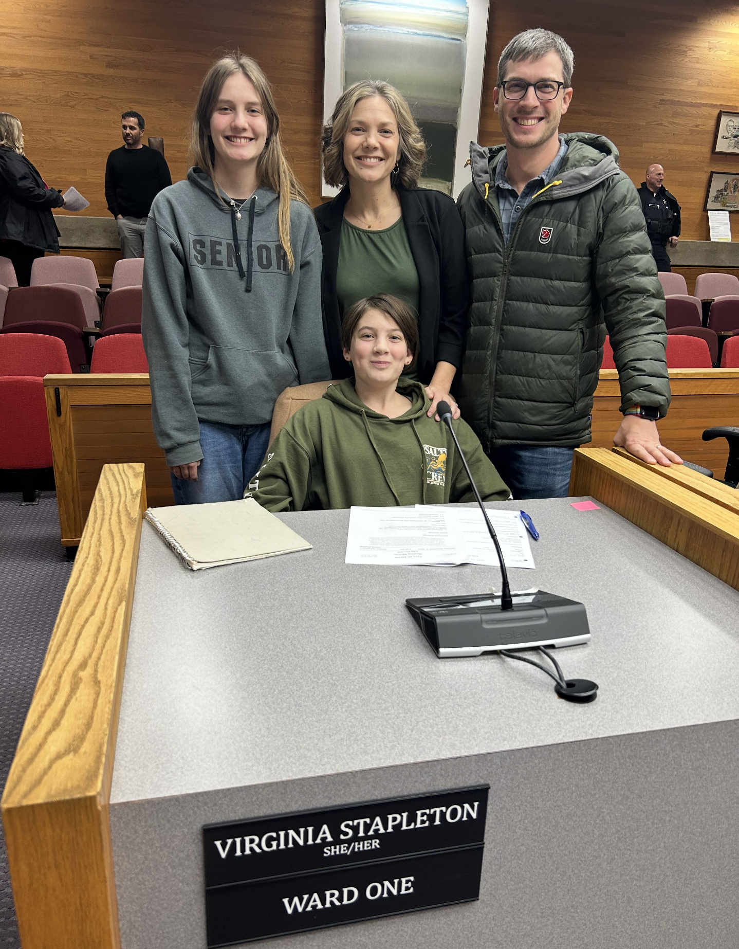 Virginia and her family at her desk at City Council