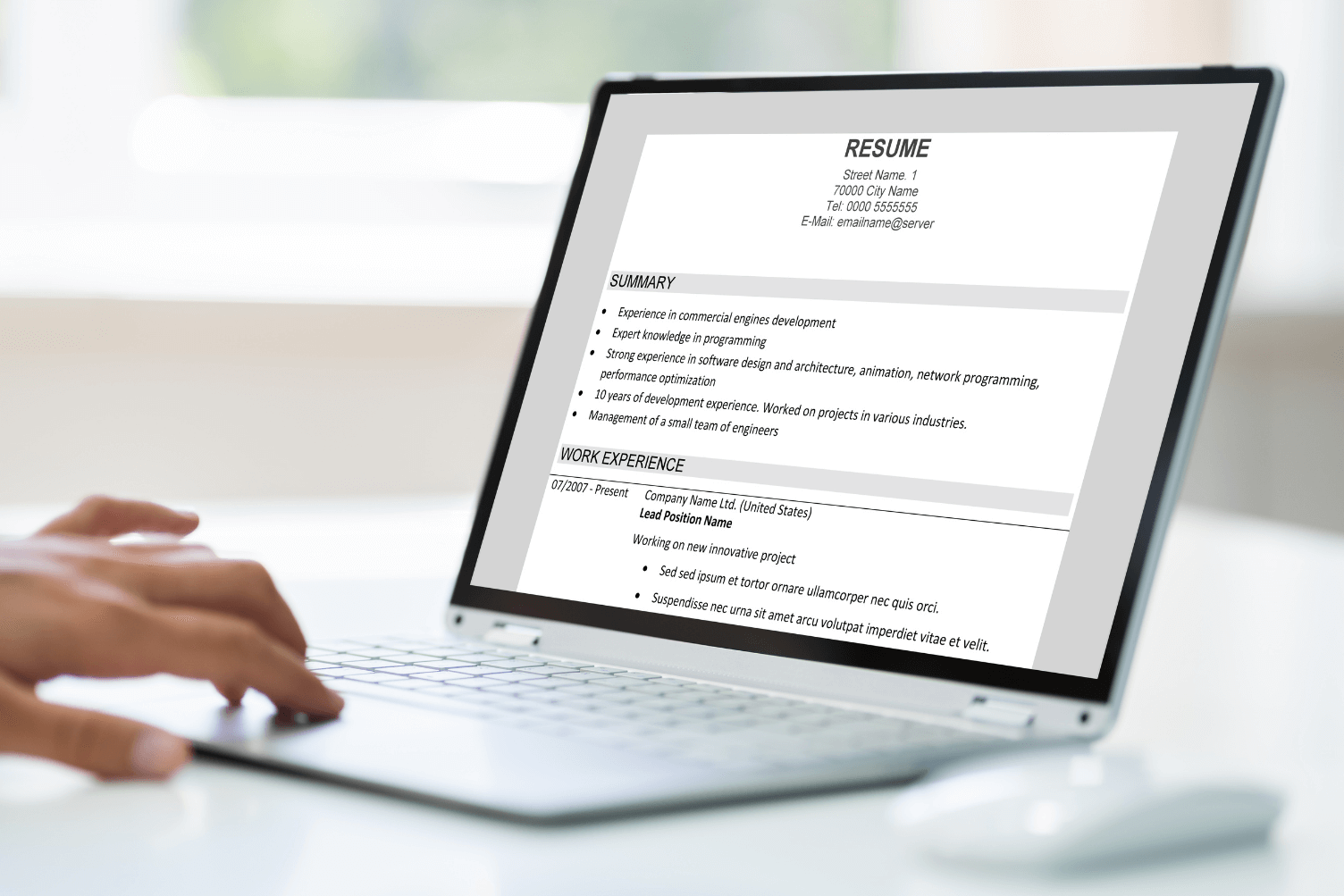 A person types on a laptop displaying a resume, focused on job applications.