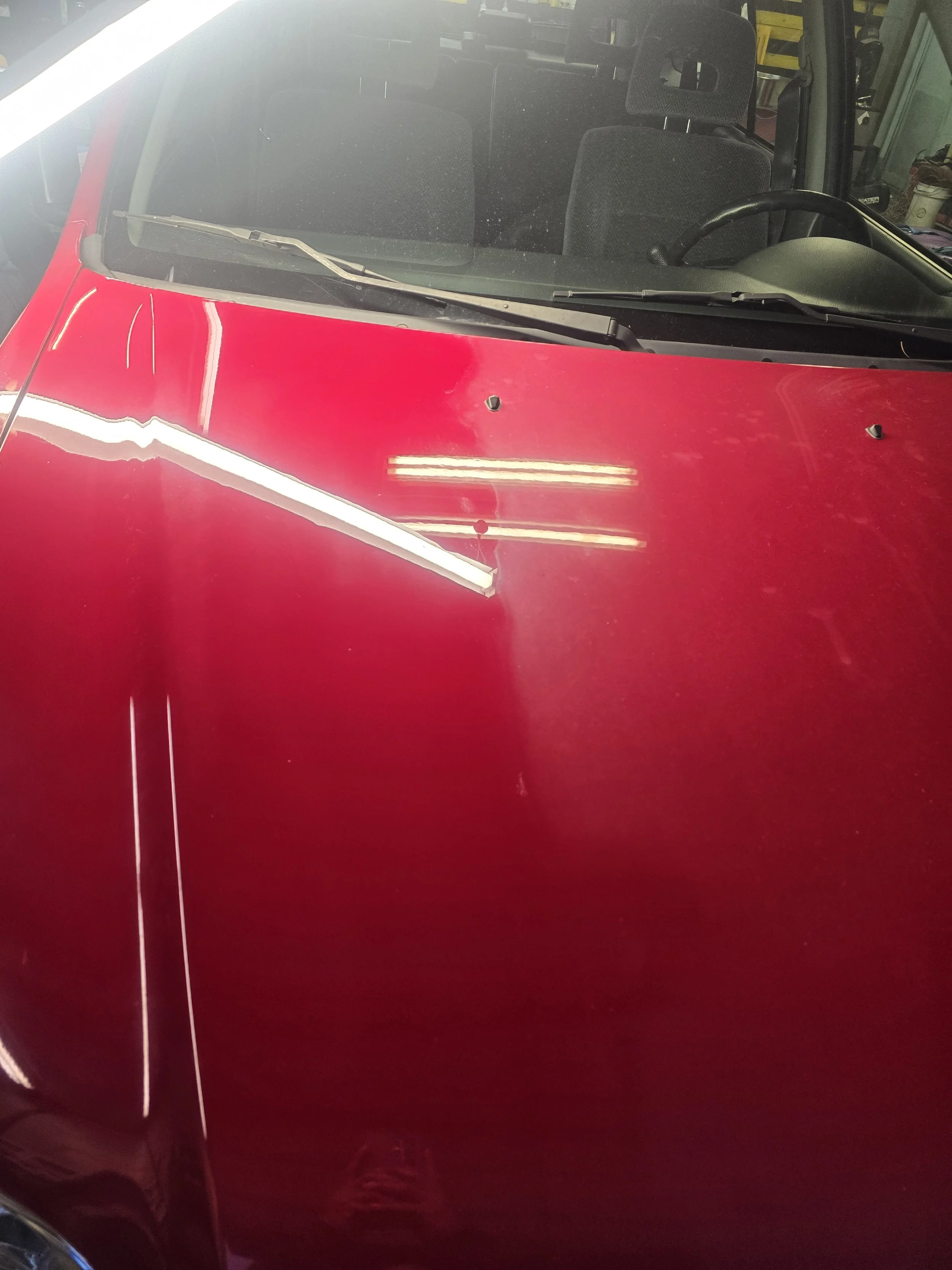 "technician performing heavy-duty paint correction on a vehicle in Louisville."