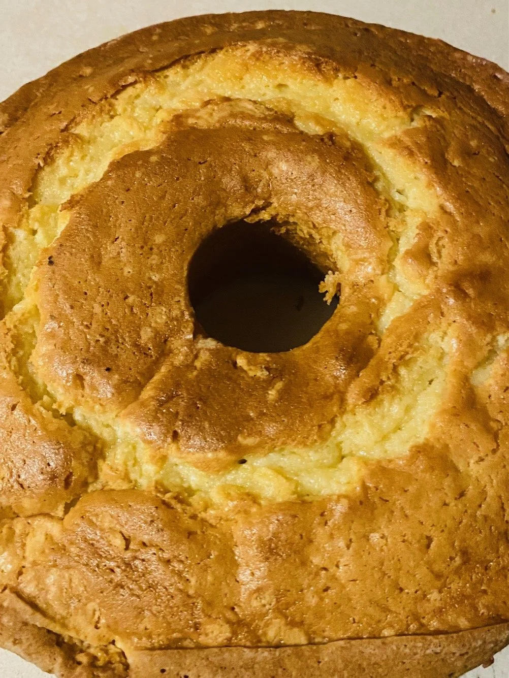 Close-up of a sliced pineapple upside-down cake with a golden-brown crust and caramelized pineapple chunks.