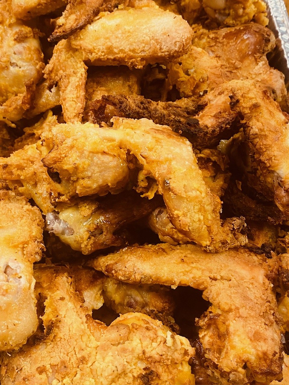 Close-up of fried chicken pieces with crispy, golden-brown coating.