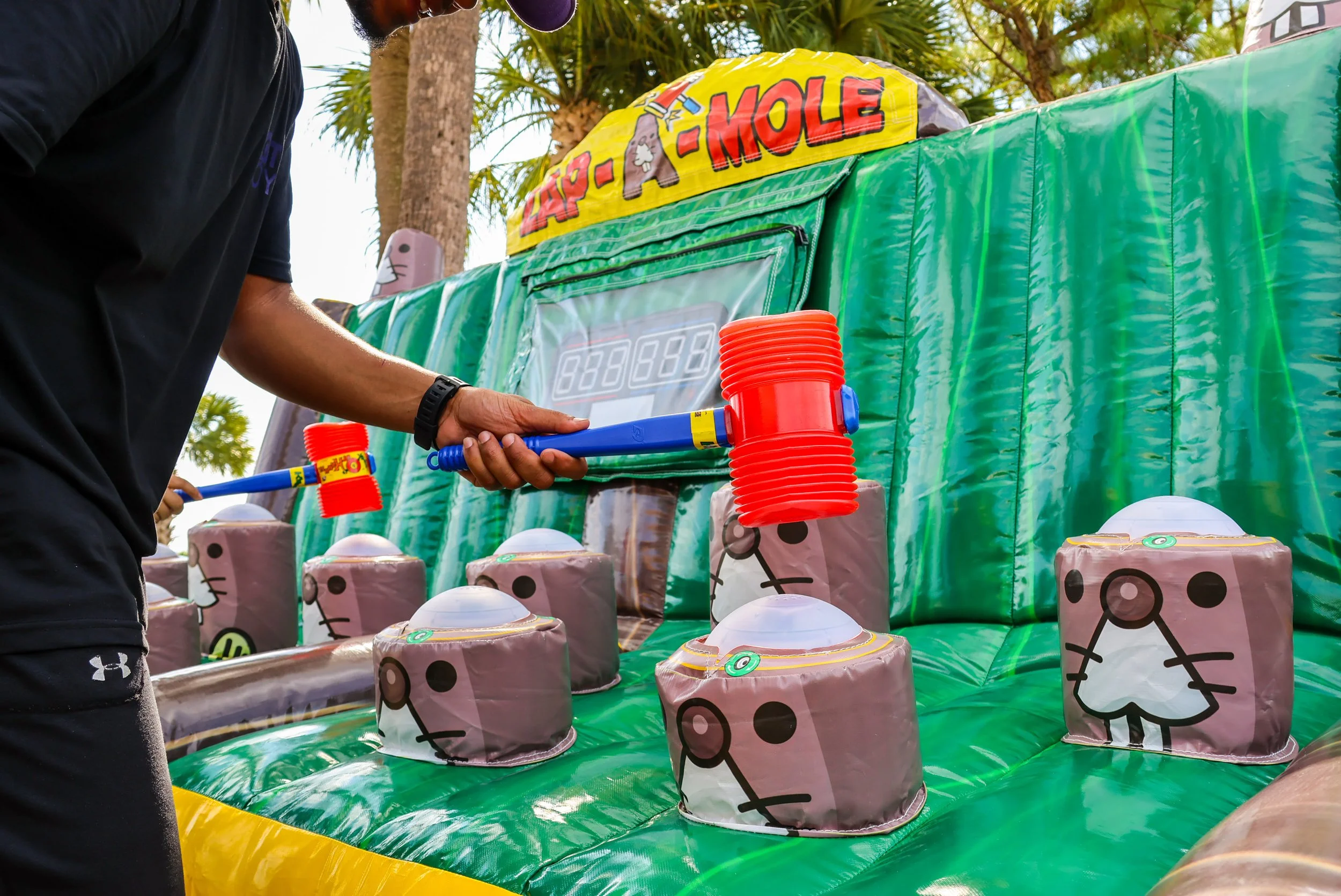 Close-up of a player aiming the mallet at the light-up moles in the inflatable Zap A Mole game by Fotoboyz Events, capturing the excitement and action.