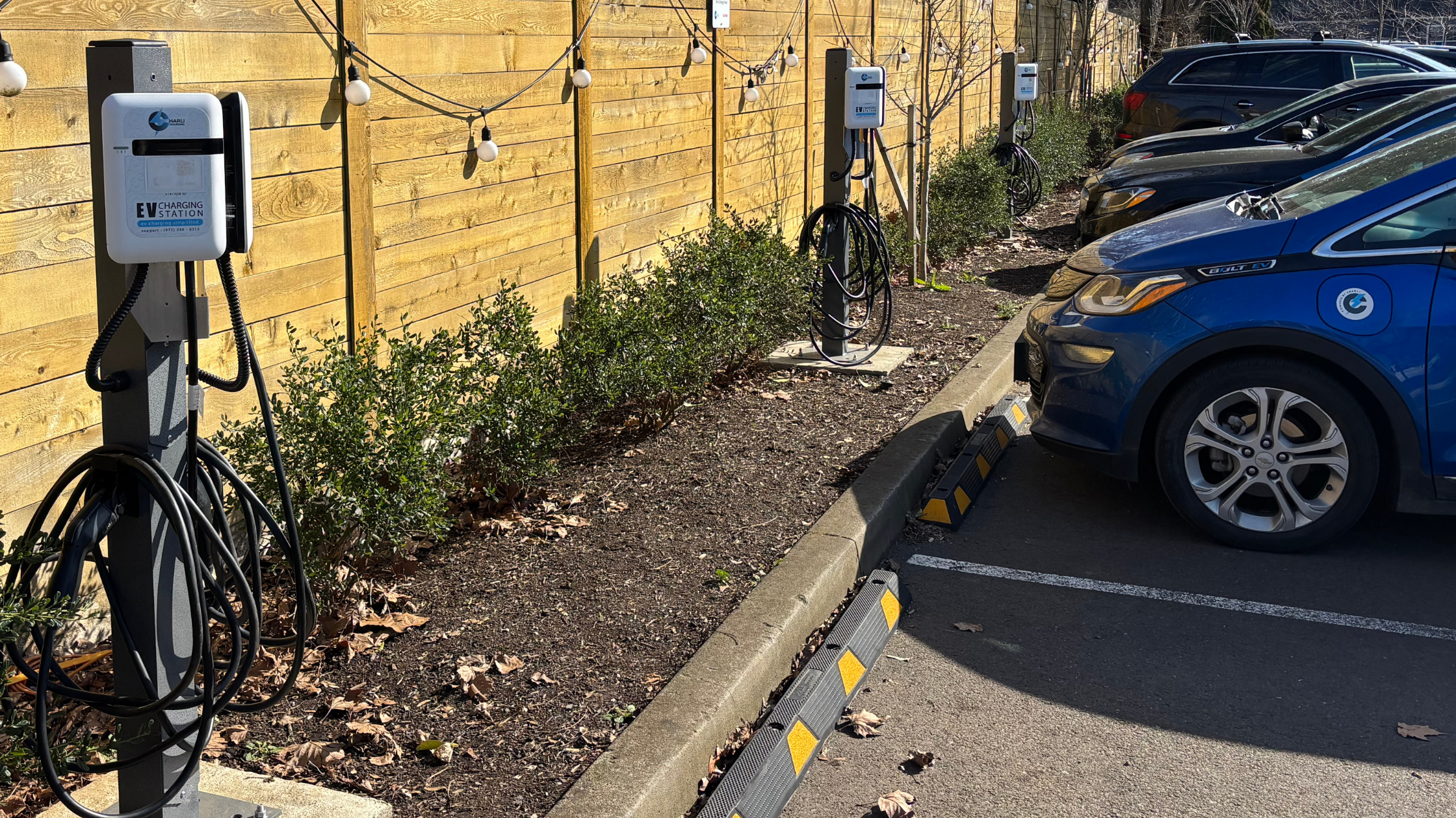 Charli Charging EV charging stations installed at C.O.R.E. Food Hall, with an electric vehicle connected to a charger in the property parking area.