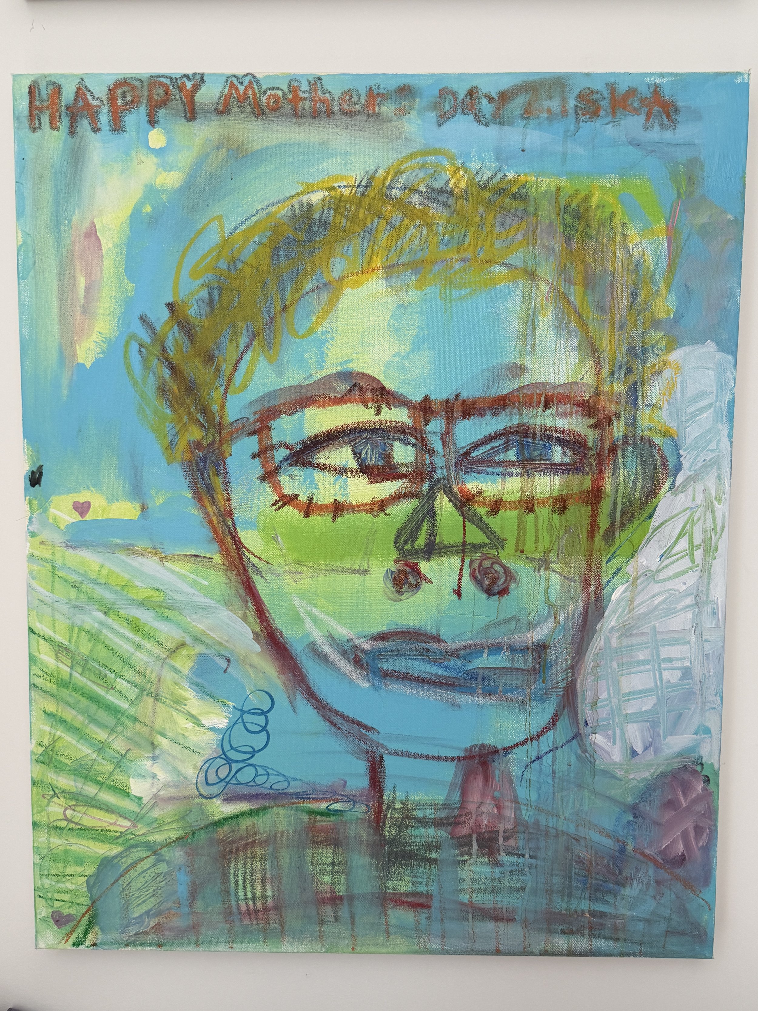 A colorful abstract painting with a blue background, featuring a large face with glasses, surrounded by scribbles and shapes, with the words "Happy Mother" written at the top.