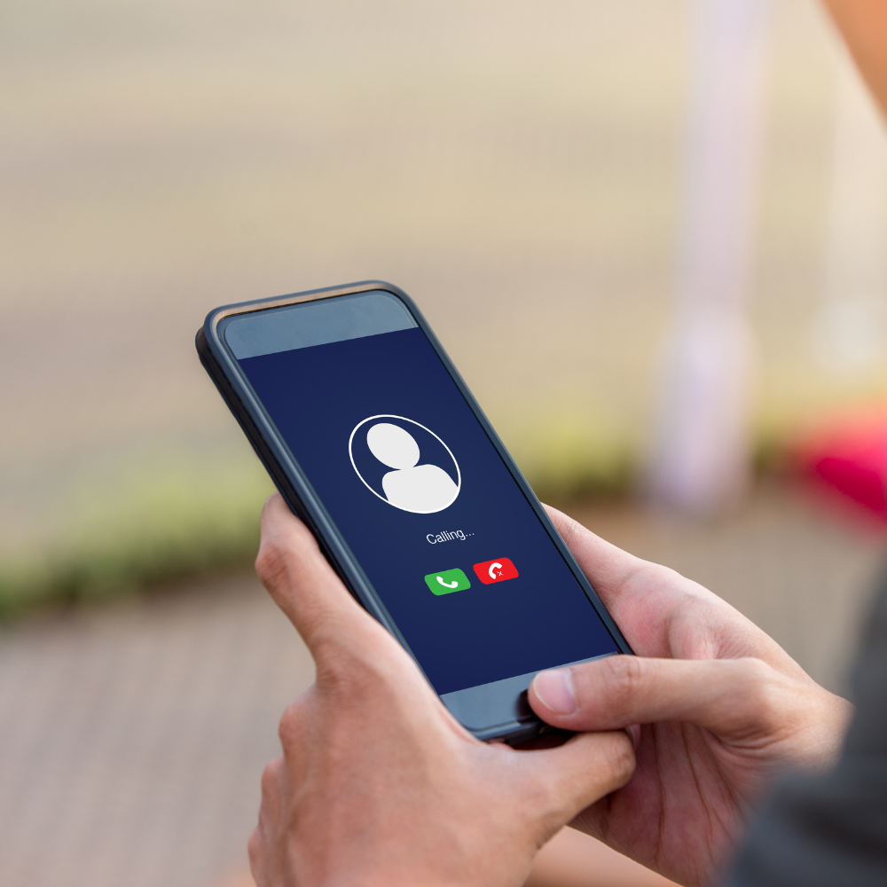 A person holding a smartphone displaying an incoming call screen with options to answer or decline.