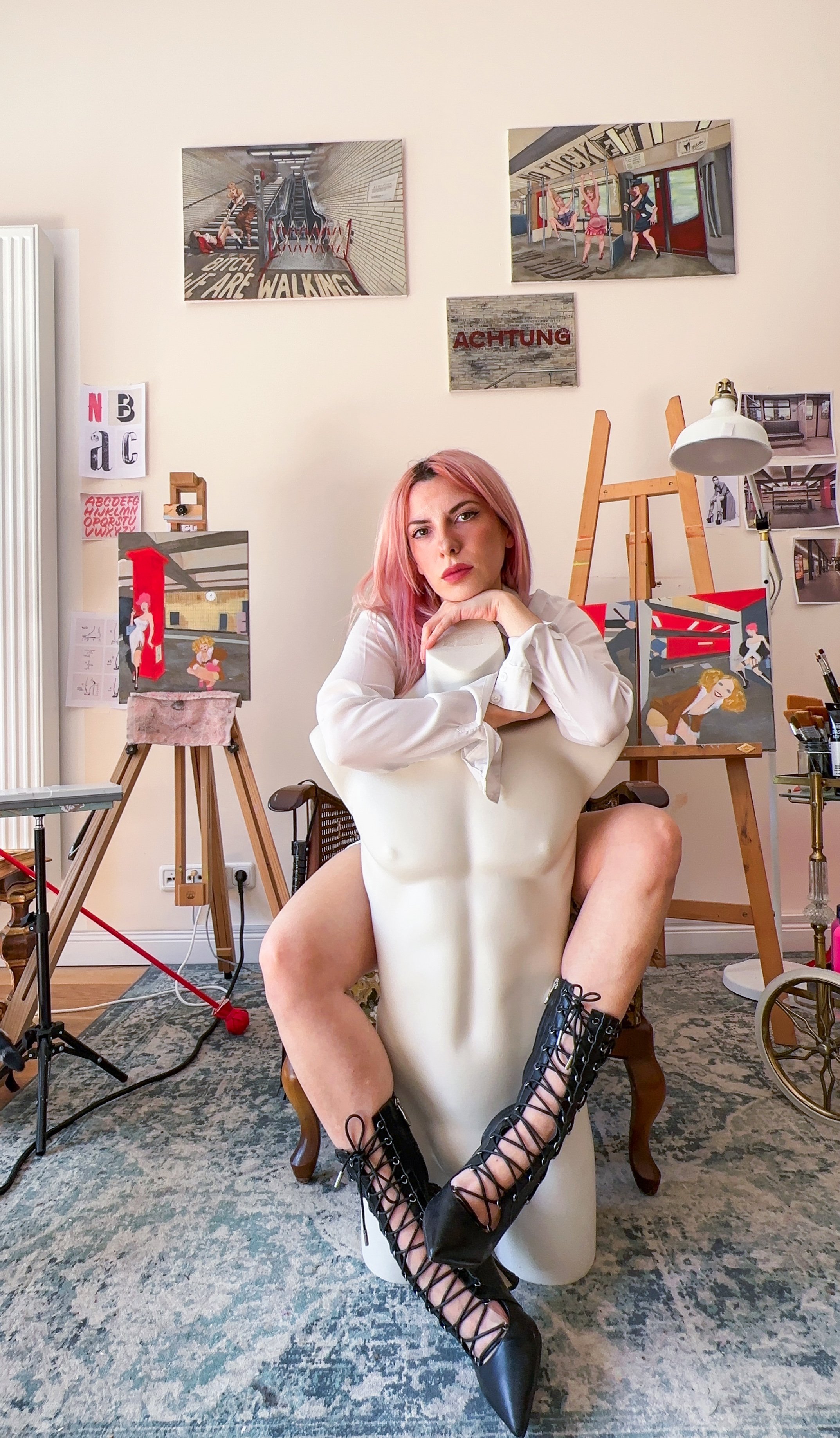 The artist Antonella Nicoli in her studio with some artwork behind her.