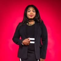 Photo of attorney Lilian O. Audu, wearing a black suit with white accents, in front of a red background