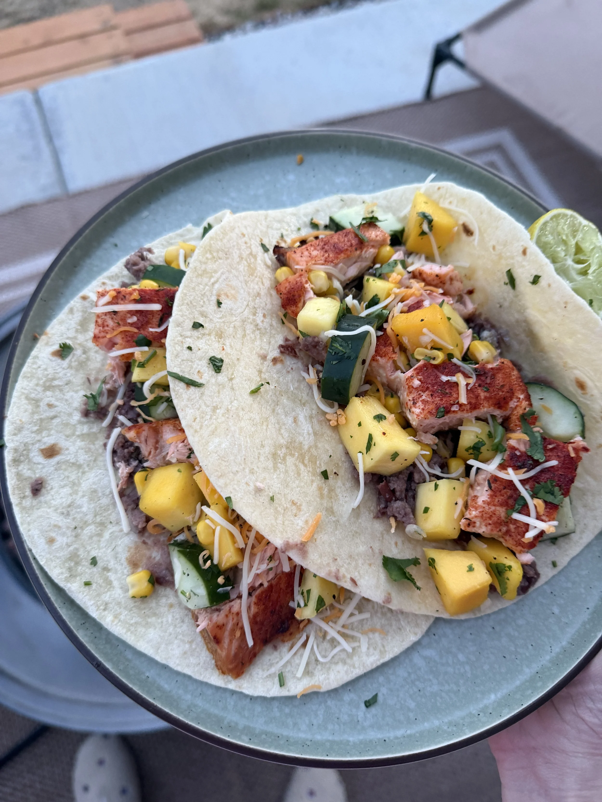 image of two salmon tacos with mango corn salsa on a plate