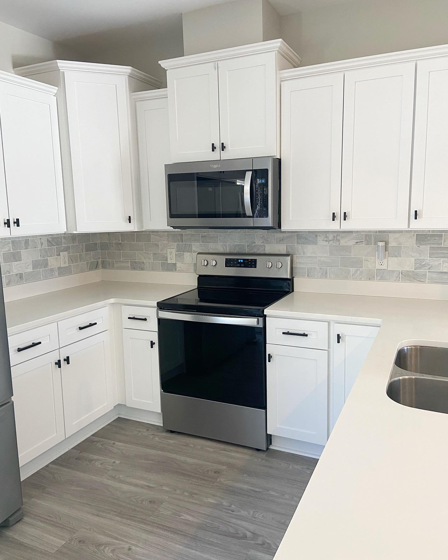 Brand new kitchen tile backsplash to replace the previous wallpaper, black cabinet hardware to replace the gold, and black bar lights to replace the silver. Swipe for the before picture at the very end.