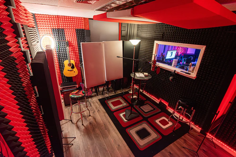 Red-lit vocal booth at The Continental Studios with a window into the control room