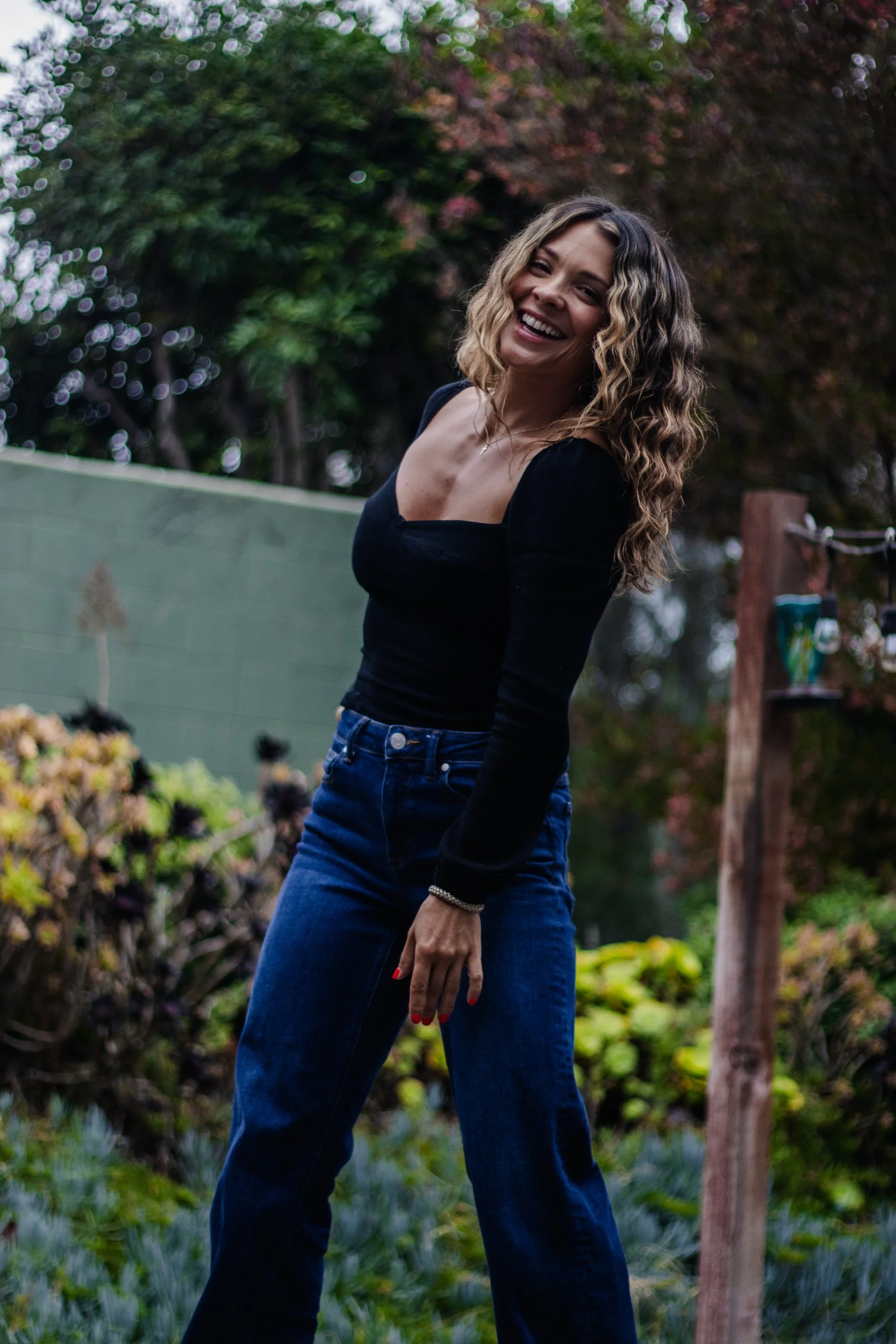 woman in black shirt and jeans standing confidently.jpg