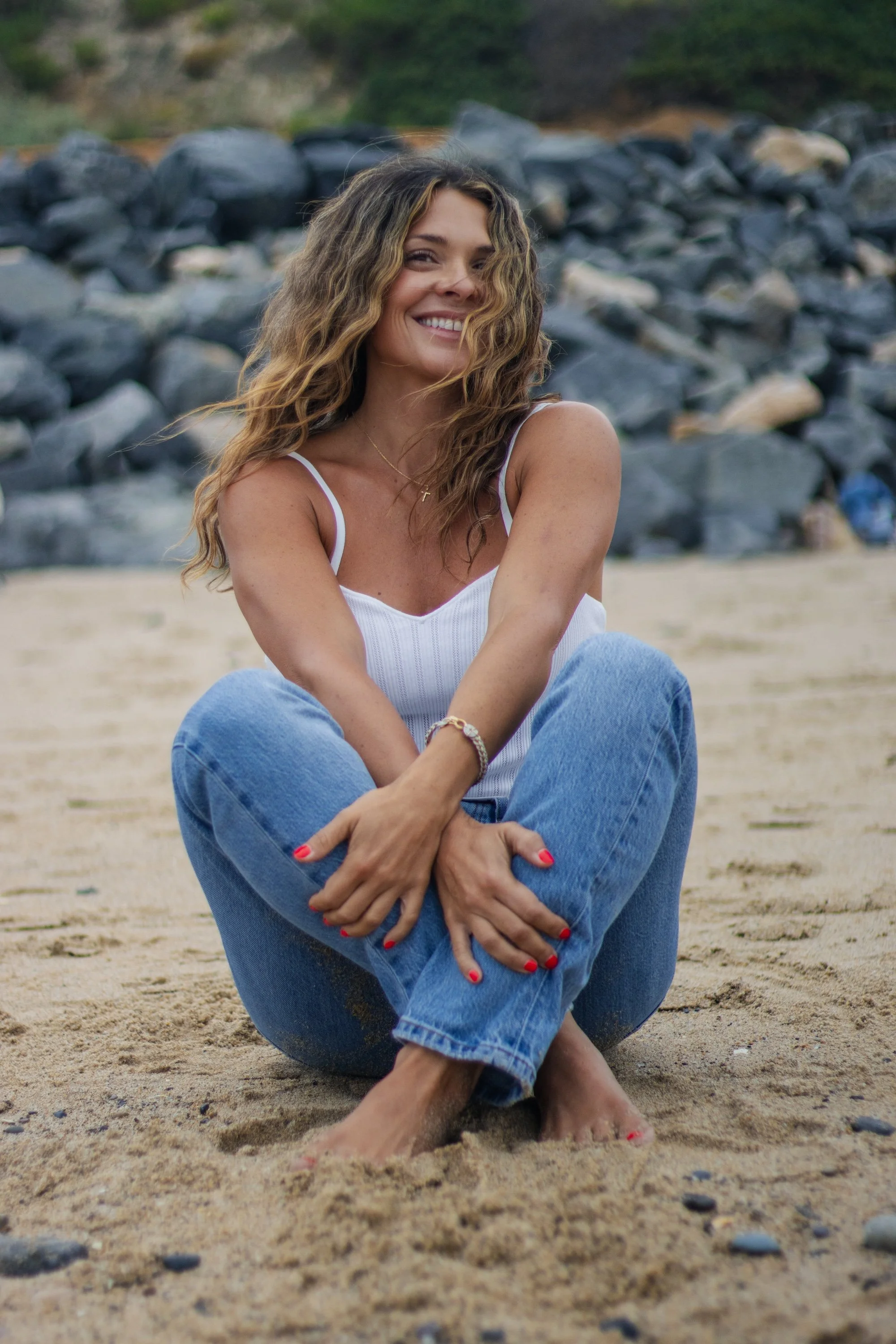woman sitting on the sand in jeans.jpg