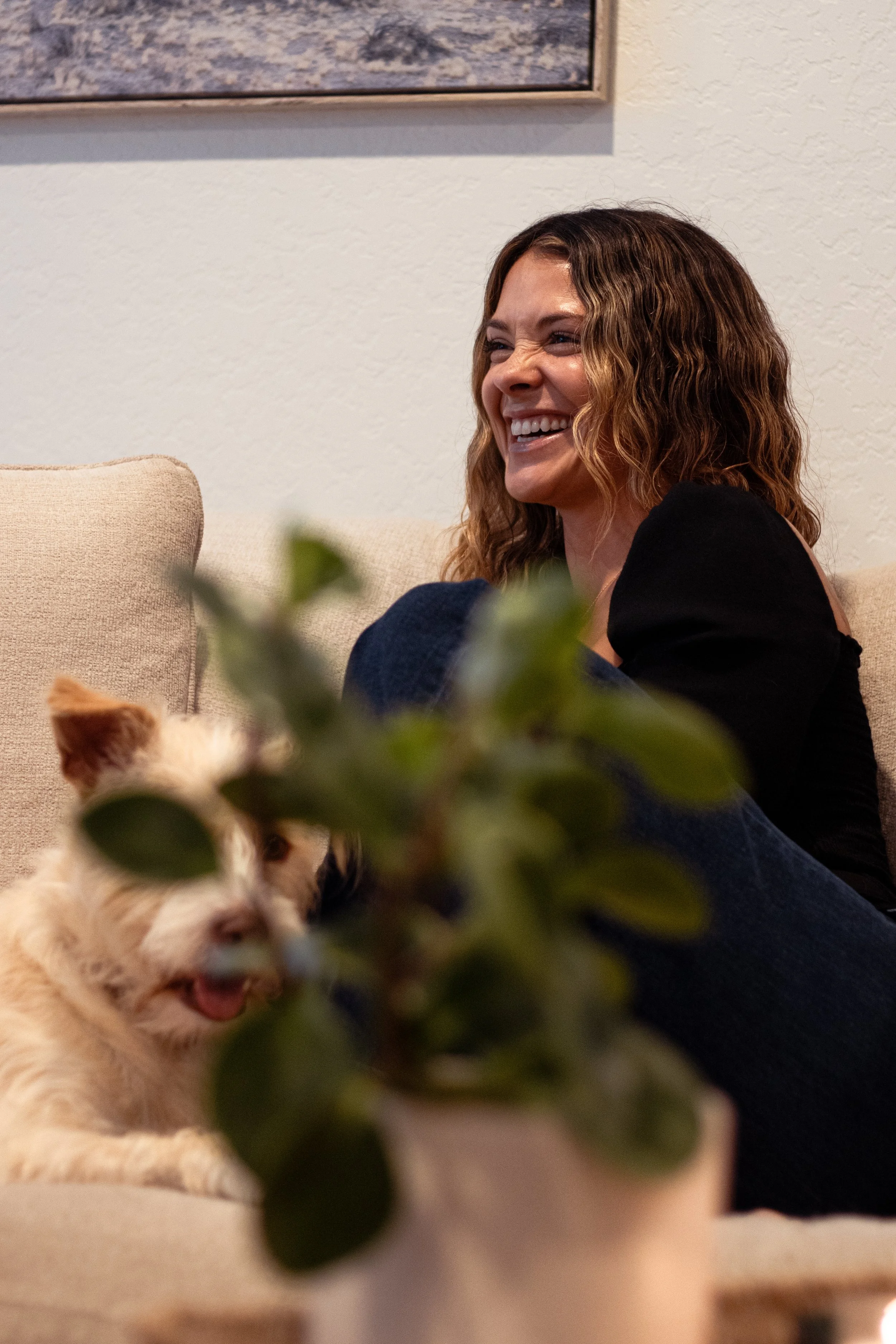 woman with her dog laughing on a couch.jpg