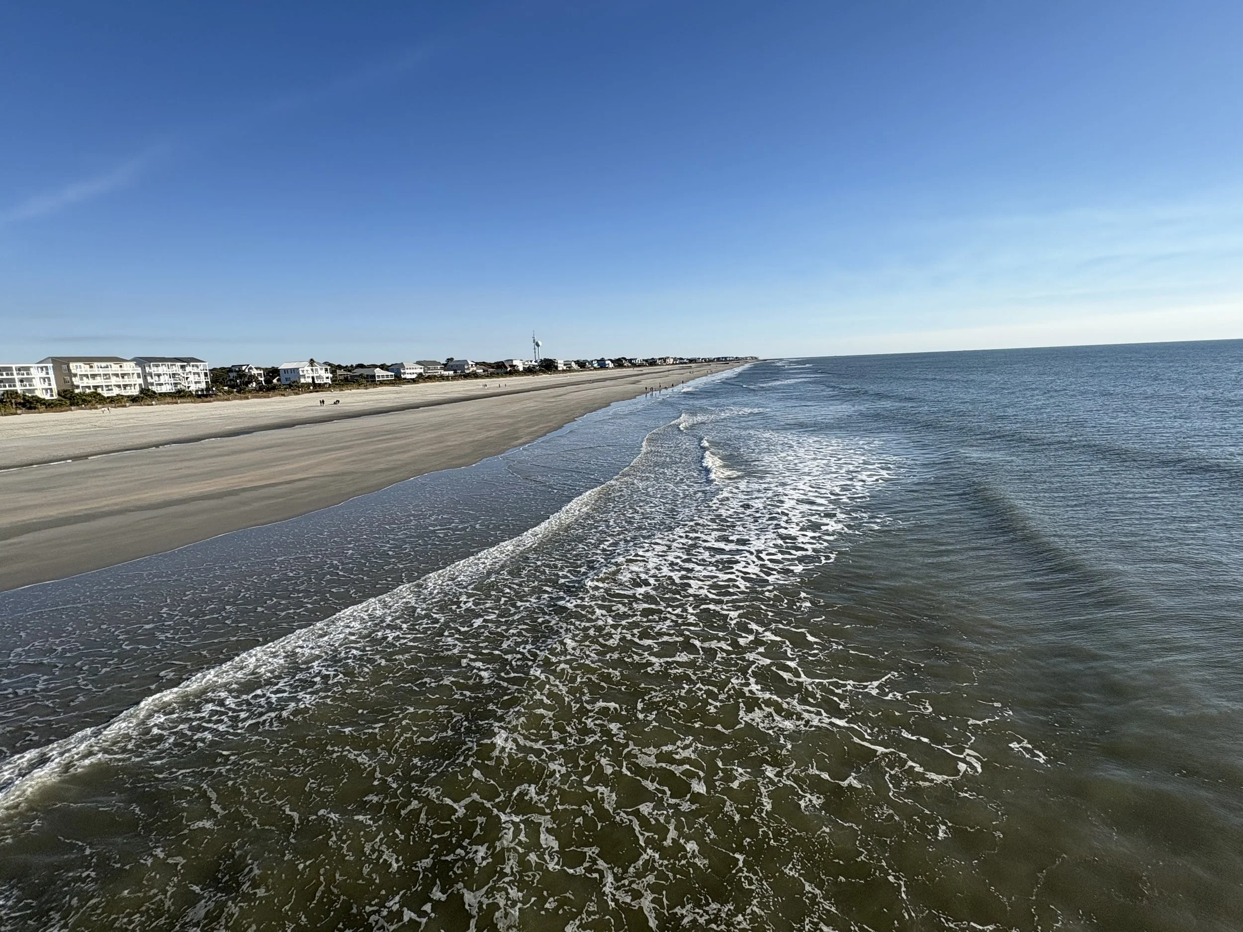 Sunny beach scene with ocean and blue sky