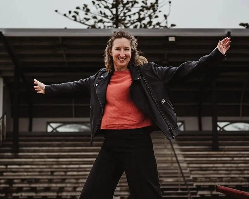 Two people touching hands with a background of a window and blurred greenery outside.