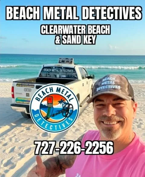 A man in a gray cap and pink shirt taking a selfie on the beach, with a white pickup truck in the background that has a blue, black, and white logo reading "Beach Metal Detectives." The logo features an illustration of a metal detector, palm trees, a sunset, and water. The image promotes Beach Metal Detectives at Clearwater Beach and Sand Key, with a contact number 727-226-2256.