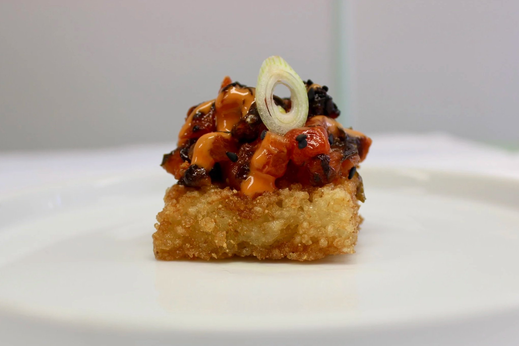 vegan tuna made from watermelon on crispy rice with black sesame seeds and spring onion, beautiful plant-based canapé for catering
