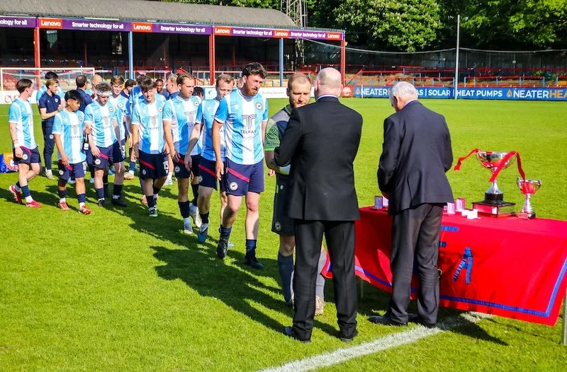Whitehill &amp; Bordon FC players line up to collect their medals at the ADFA Saturday Intermediate Cup Final, May 2026