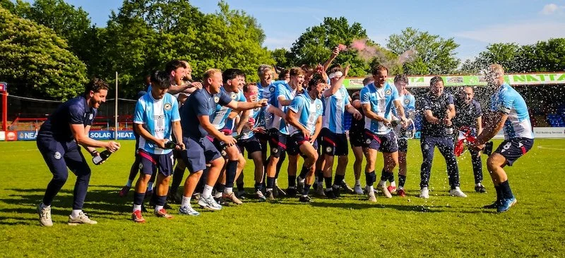 Whitehill &amp; Bordon FC players celebrate with champagne after winning the ADFA Saturday Intermediate Cup Final, May 2026