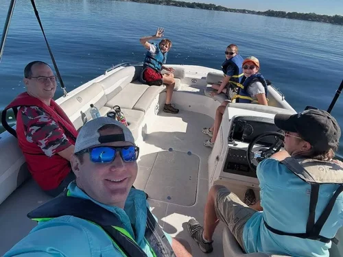 Teen in a life jacket driving the boat