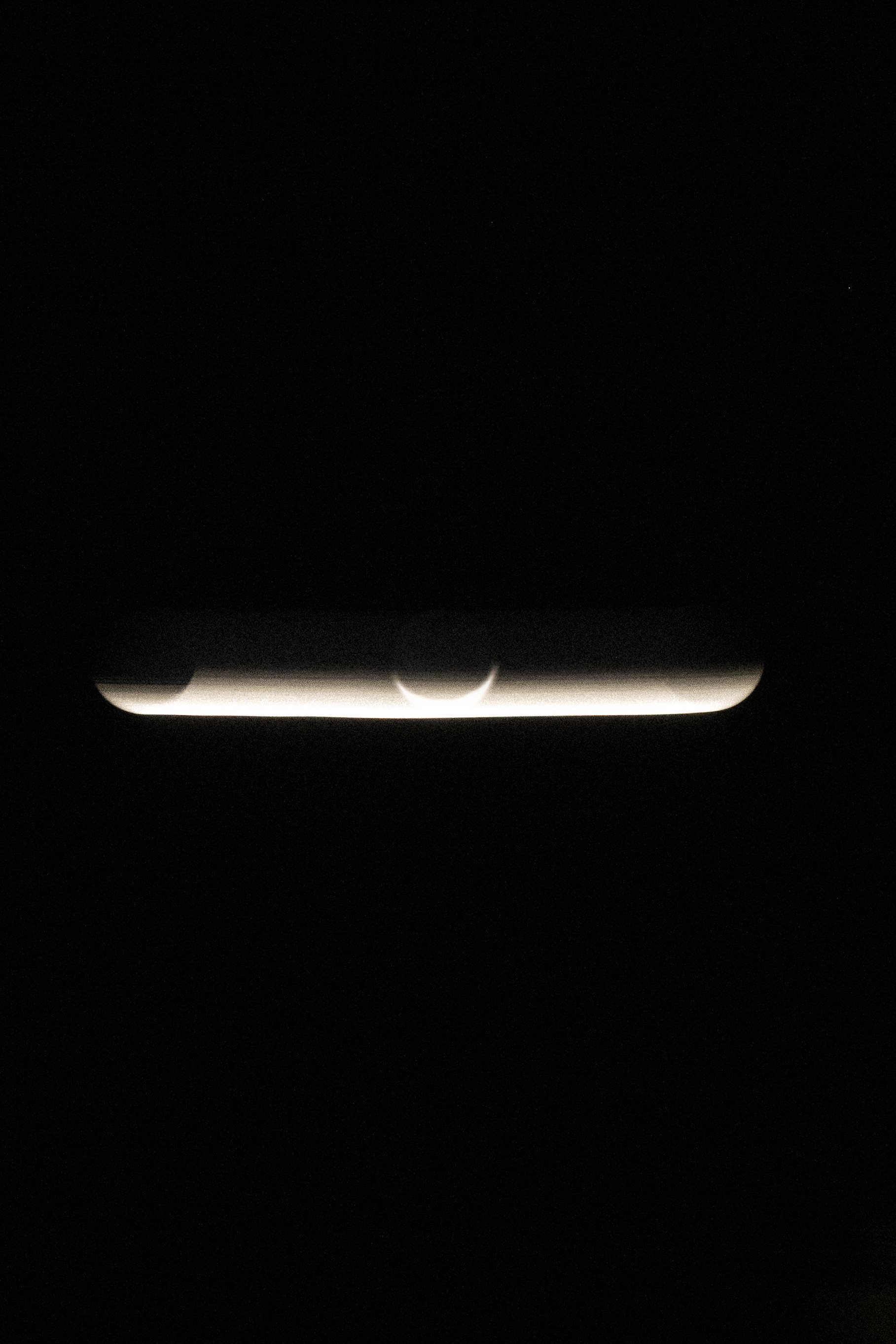 High-contrast conceptual photograph showing the luminous silhouette of an eclipse, exploring the visual relationship between the sun and the moon.