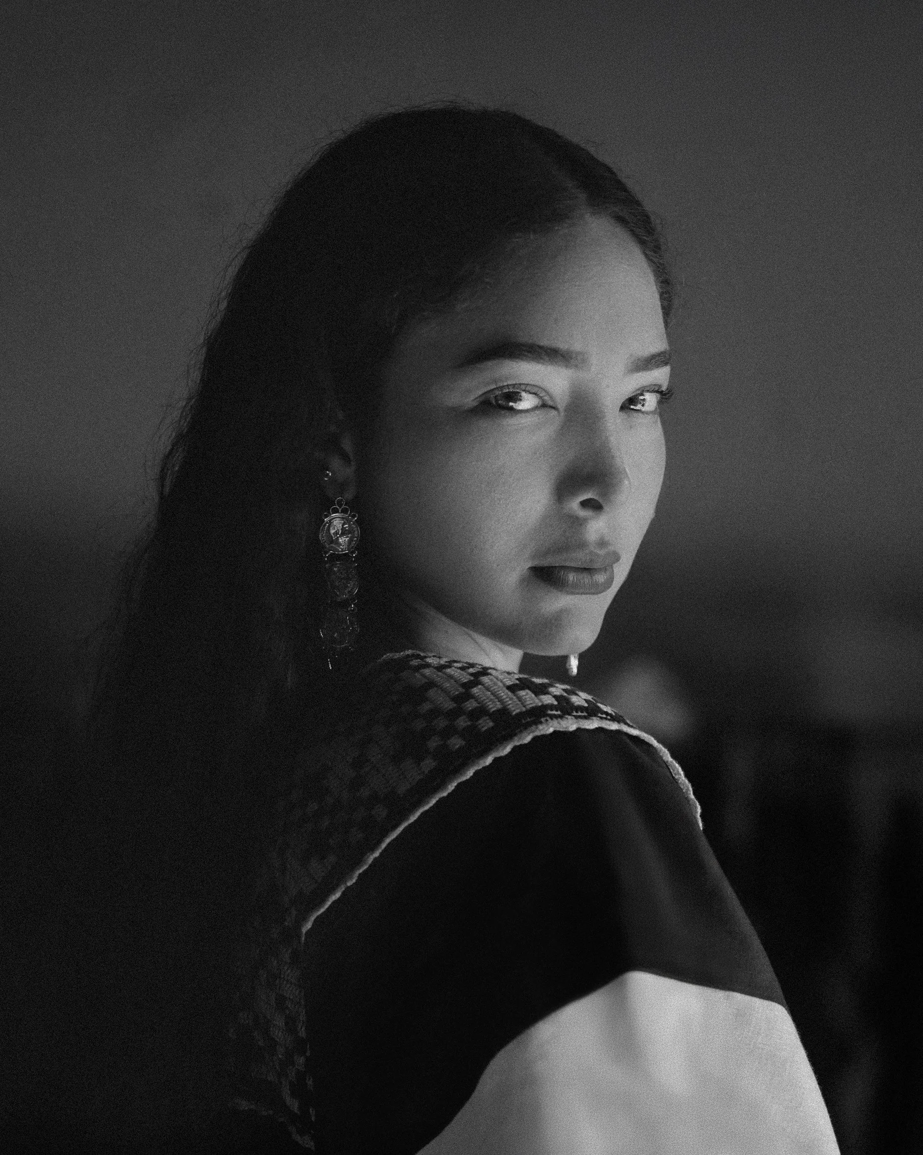 Black and white portrait of a woman looking back over her shoulder.