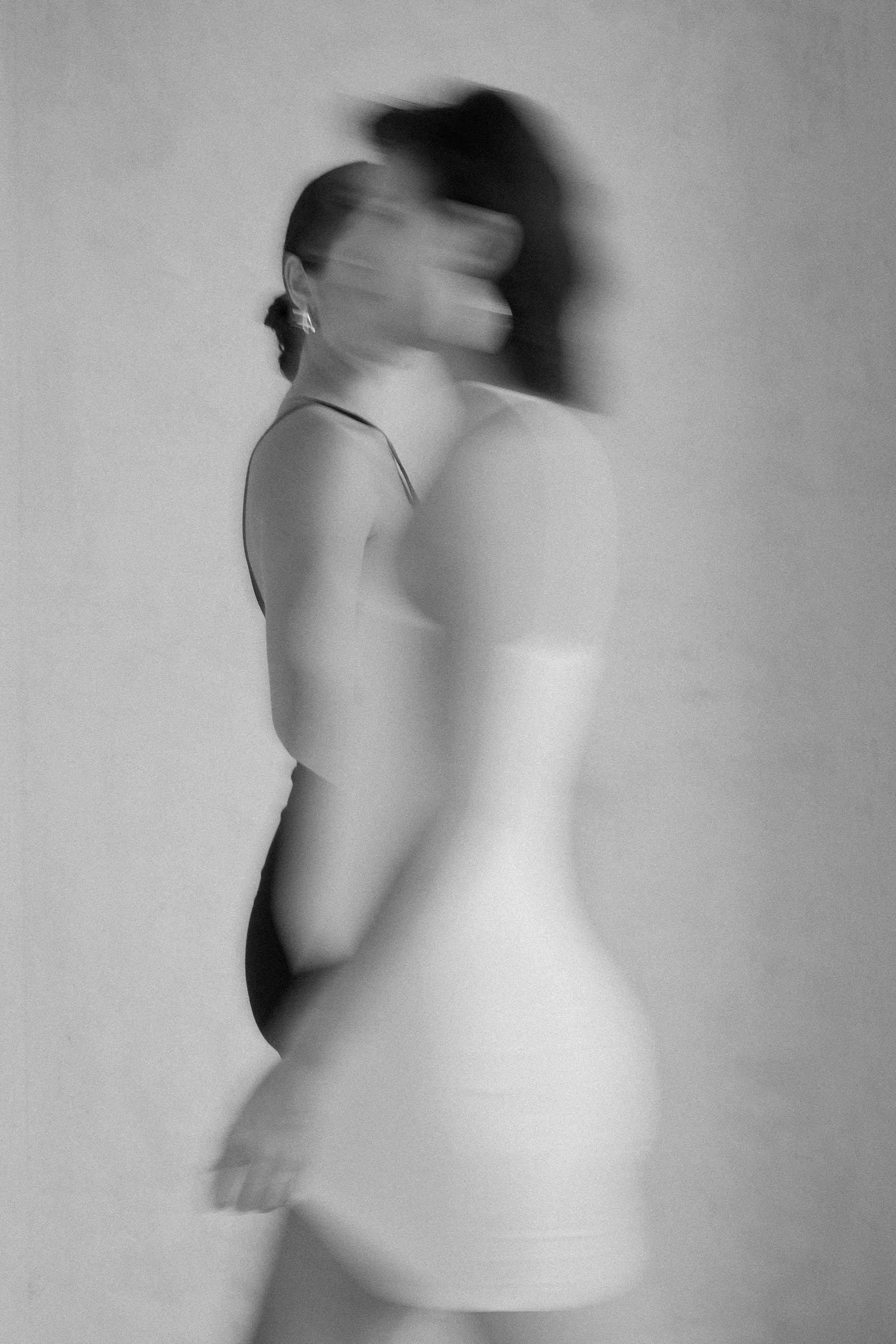 Conceptual black and white photograph featuring two figures with motion blur.