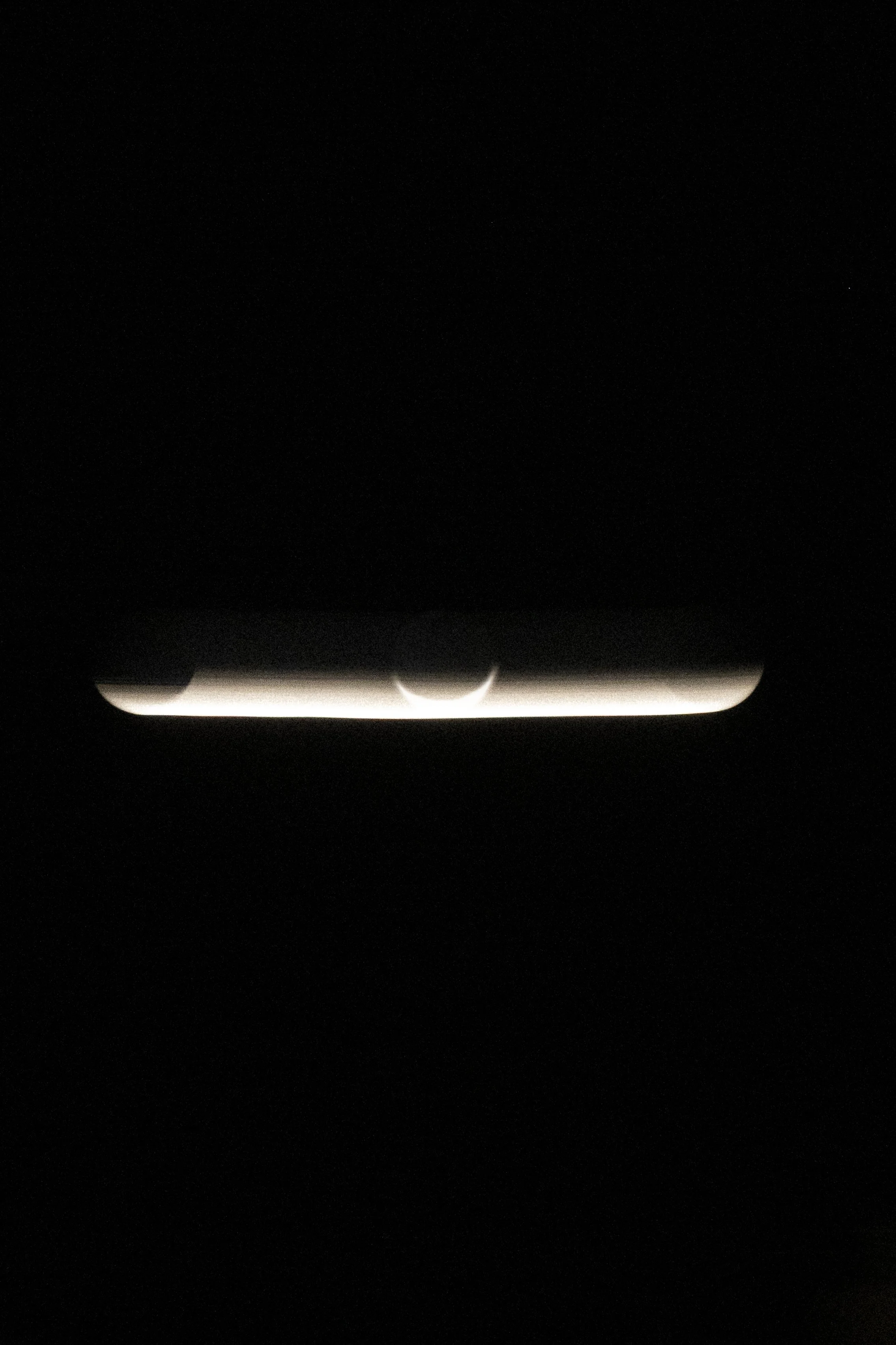 Fotografía conceptual en alto contraste mostrando la silueta luminosa de un eclipse, explorando la relación visual entre el sol y la luna.