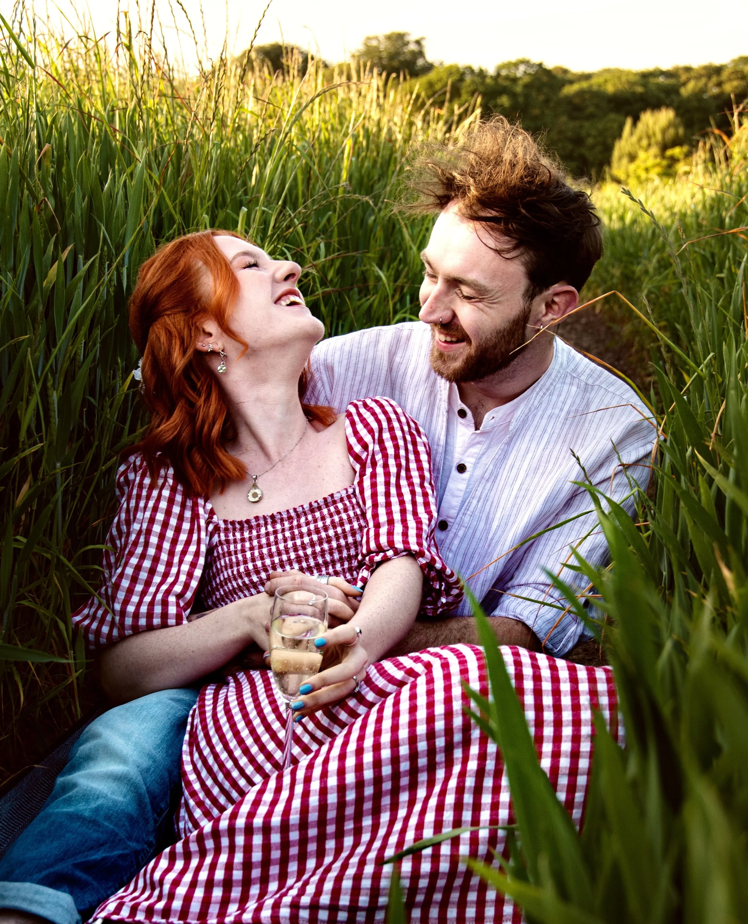 Couple relaxing together during an outdoor engagement shoot, photographed in natural light. I am a wedding photographer based in Peterborough, Cambridgeshire, offering relaxed engagement photography for couples who want natural, authentic images.