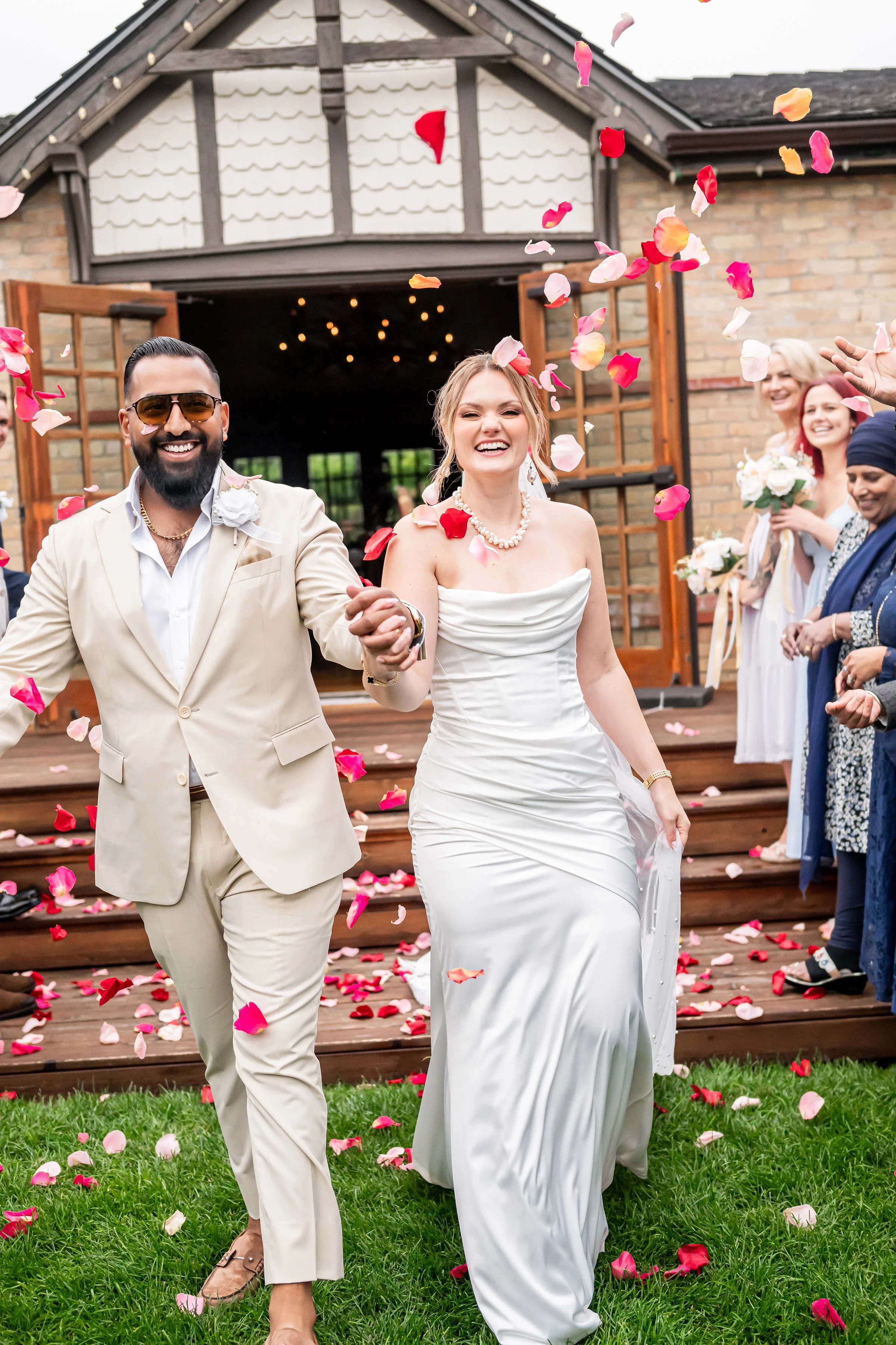 couple walking out hand in hand celebrating their marriage with family