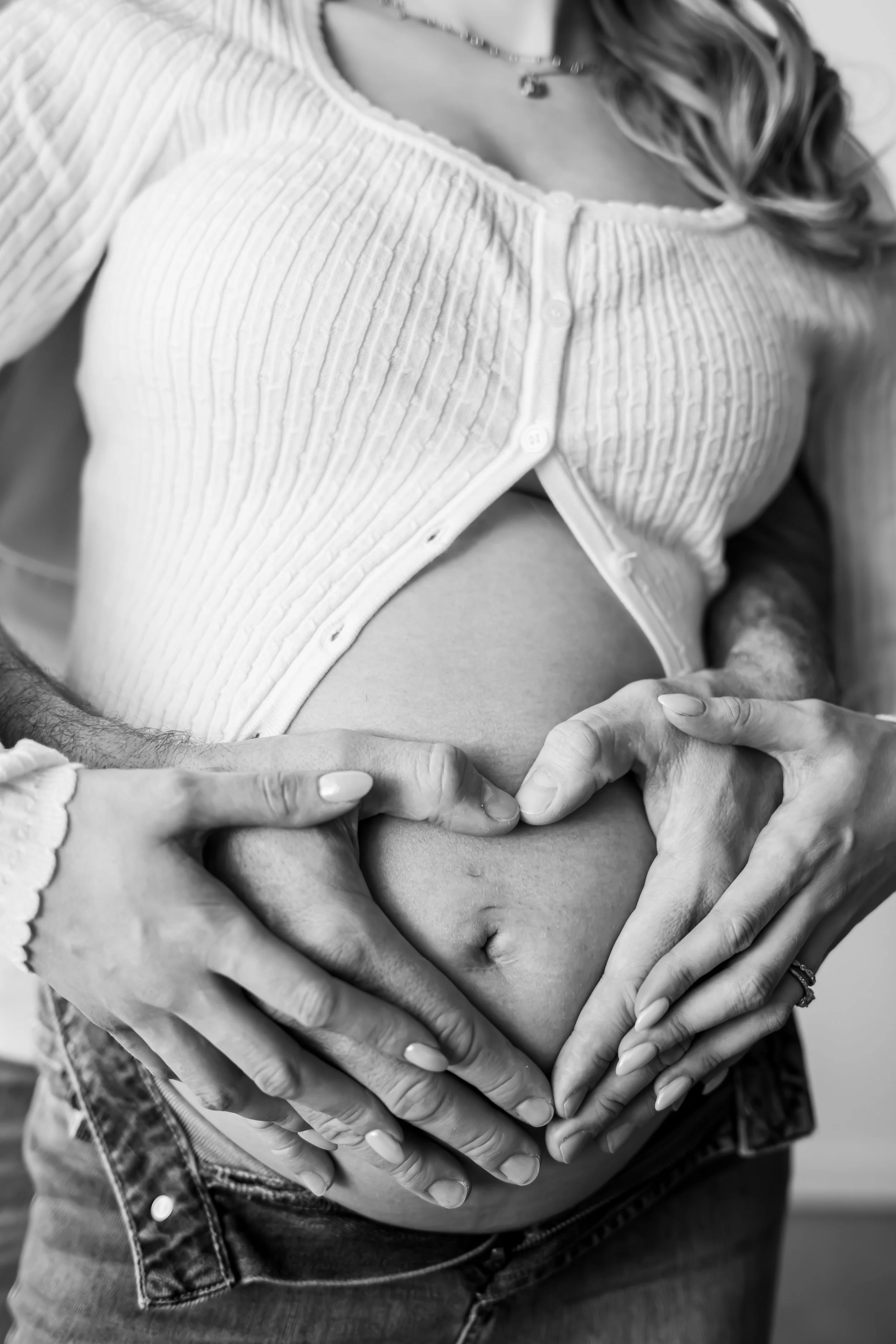 Elegant maternity portrait captured by a Calgary maternity photographer, featuring an expecting mother in a flowing gown holding her baby bump with soft natural light. A timeless pregnancy photoshoot celebrating motherhood and anticipation.