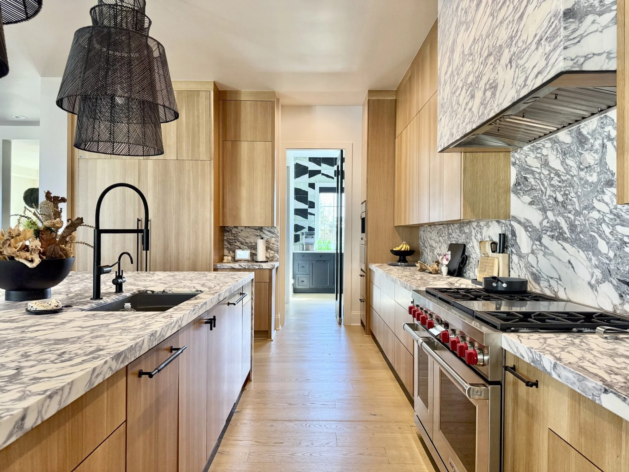 The main kitchen stays beautifully clutter-free, thanks to a butler’s kitchen just beyond — home to the ice maker, drink fridge, coffee station, and an extra stove to keep the counter mess out of sight.