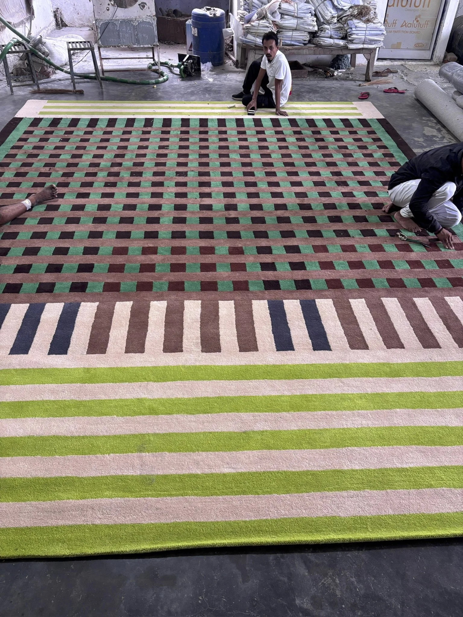 Artisans in India putting the final touches on our rug.