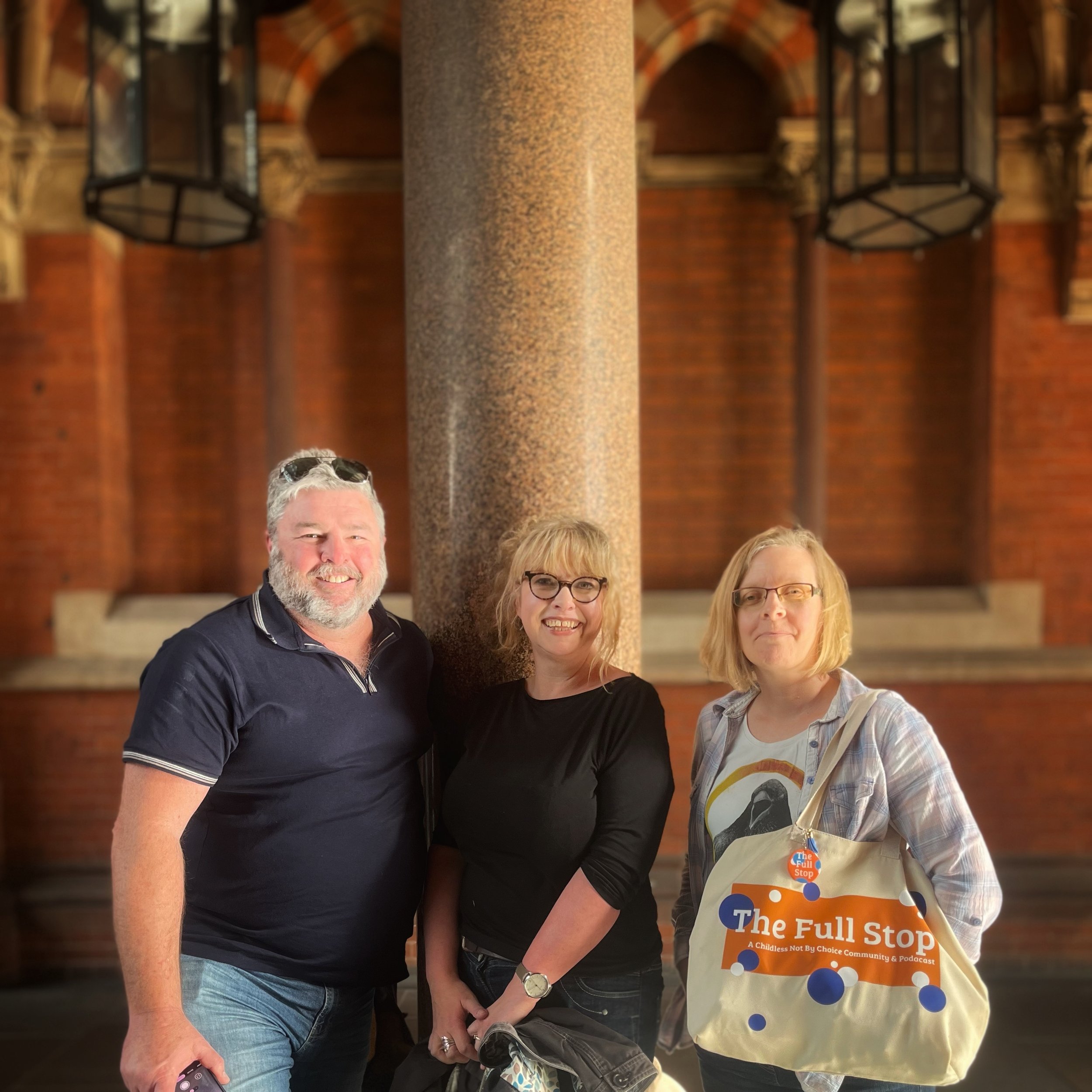 Man with beard and two women with glasses smiing at the viewer