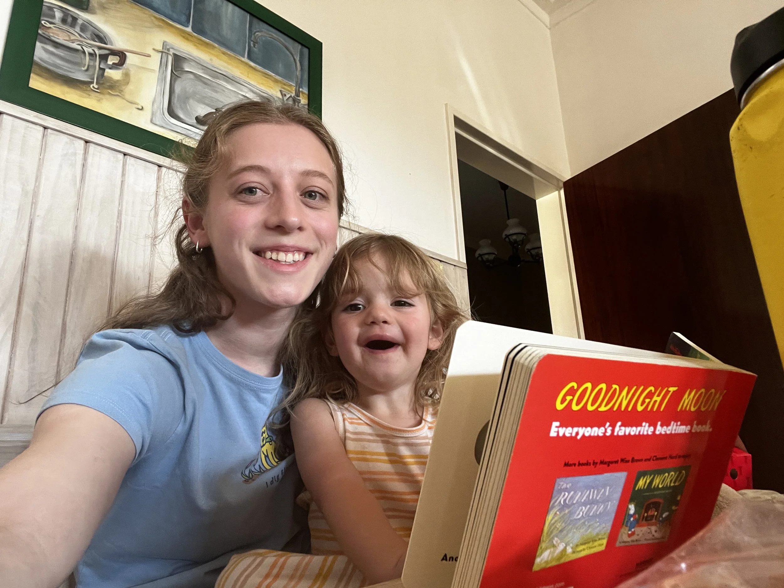 Madelyn reading a book to a young girl