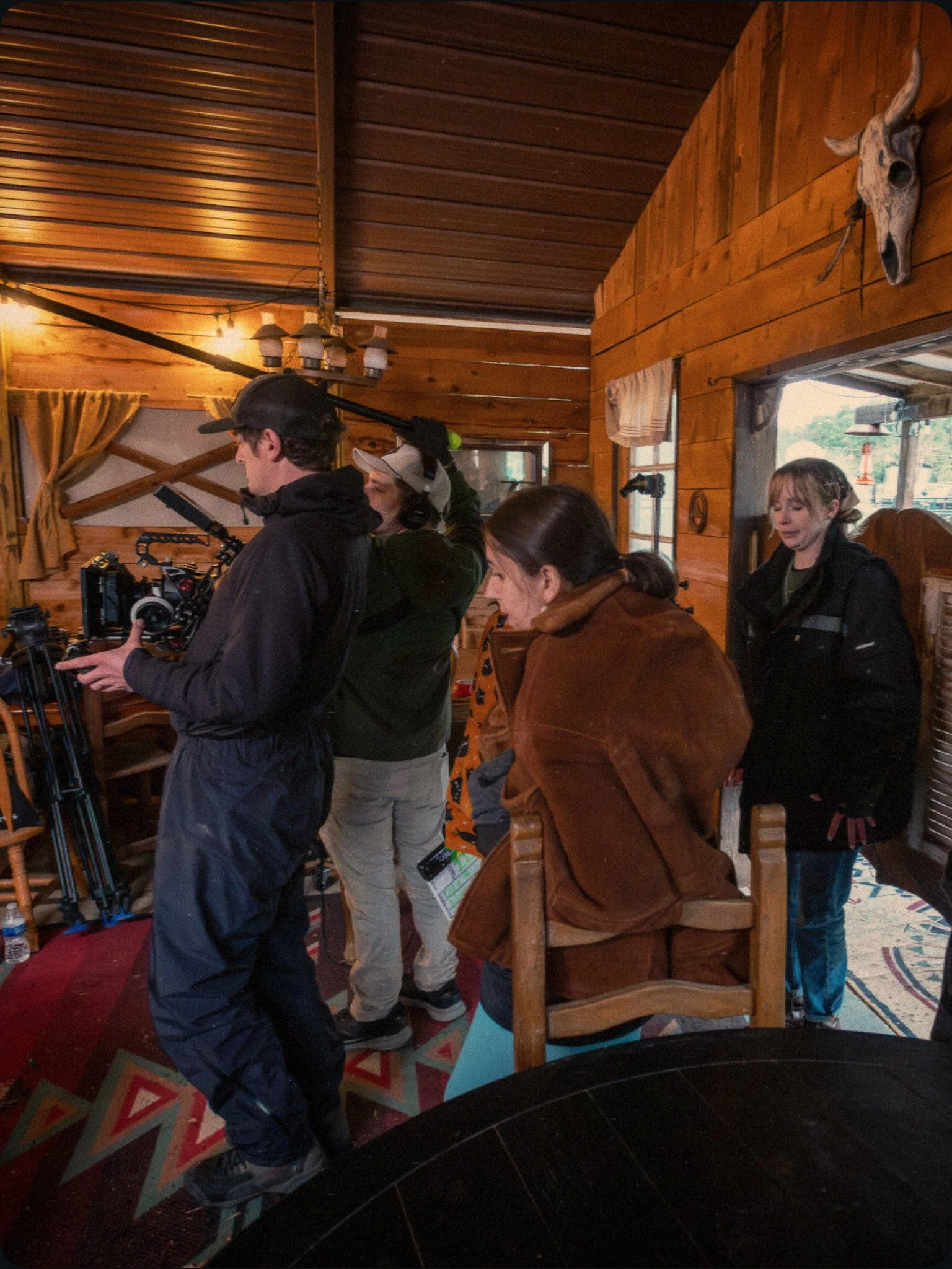 Behind-the-scenes photo of the On A Razor's Edge cast and crew  on a Western saloon set, preparing to film a handheld scene.