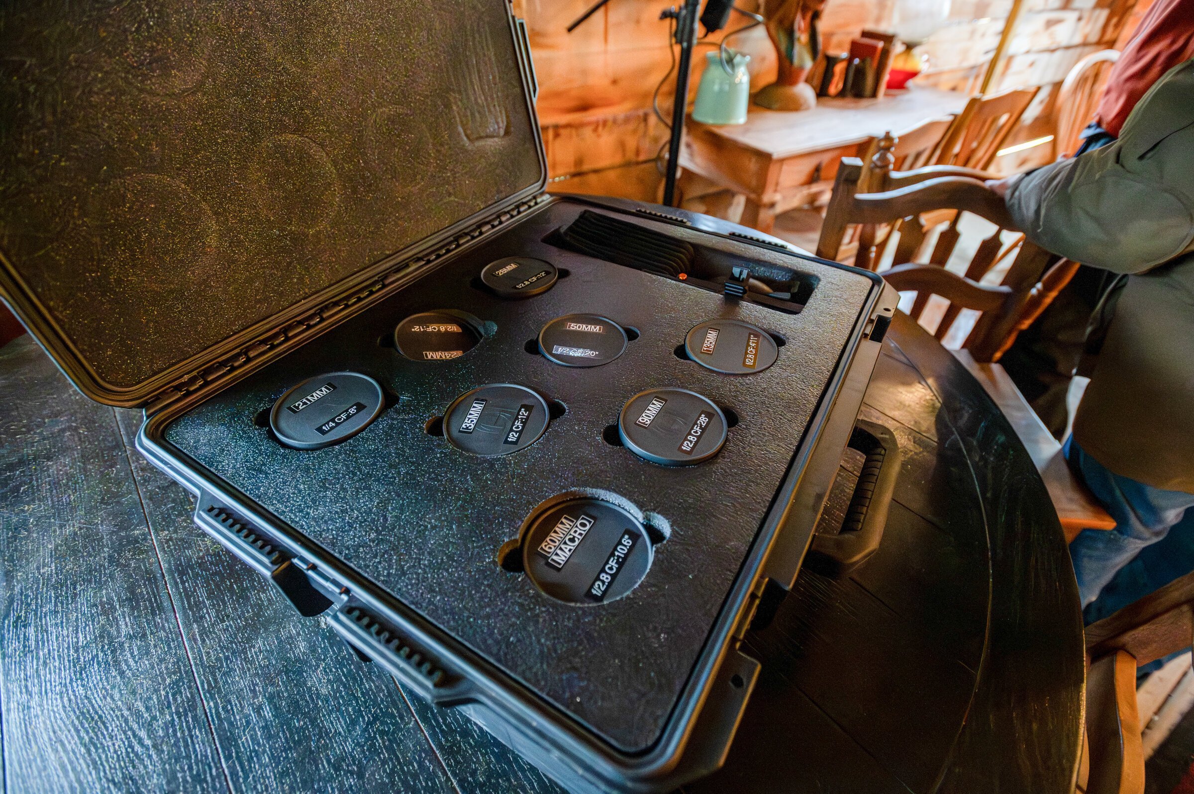 Behind-the-scenes photo of a case holding the set of Leica R prime lenses used to shoot On A Razor's Edge, resting on a table inside the saloon set.