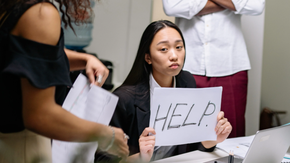 office worker holding up a help sign