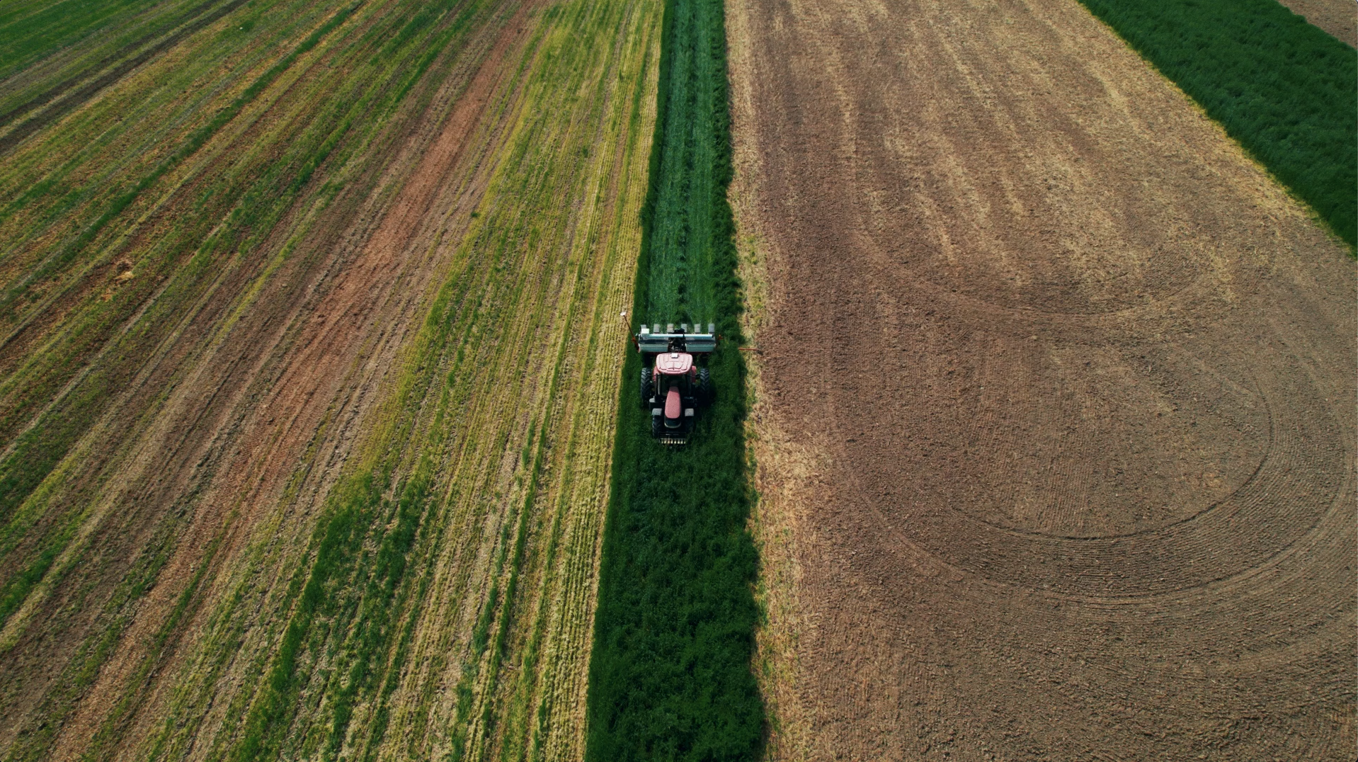 Drone aerial videography of tractor on large farm