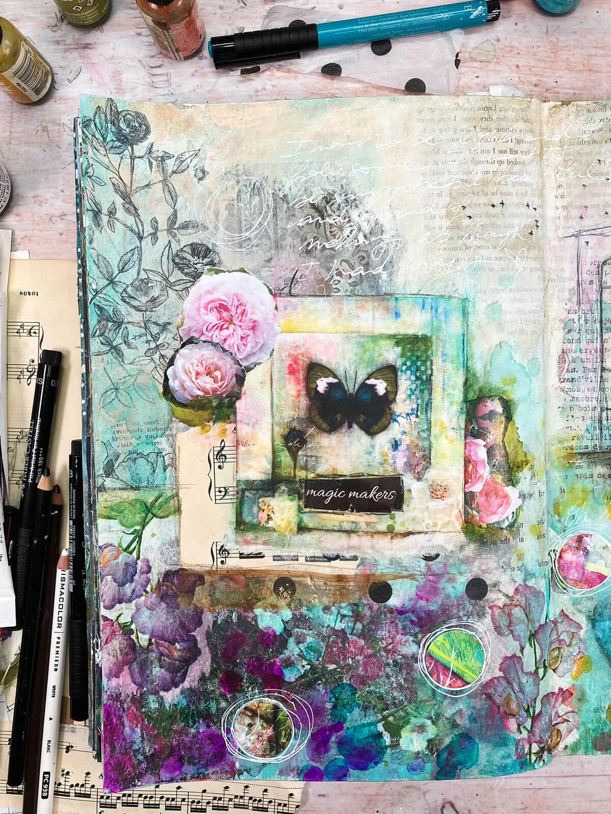 Colorful art journal page with butterfly, roses, floral image transfer and the words "magic makers".