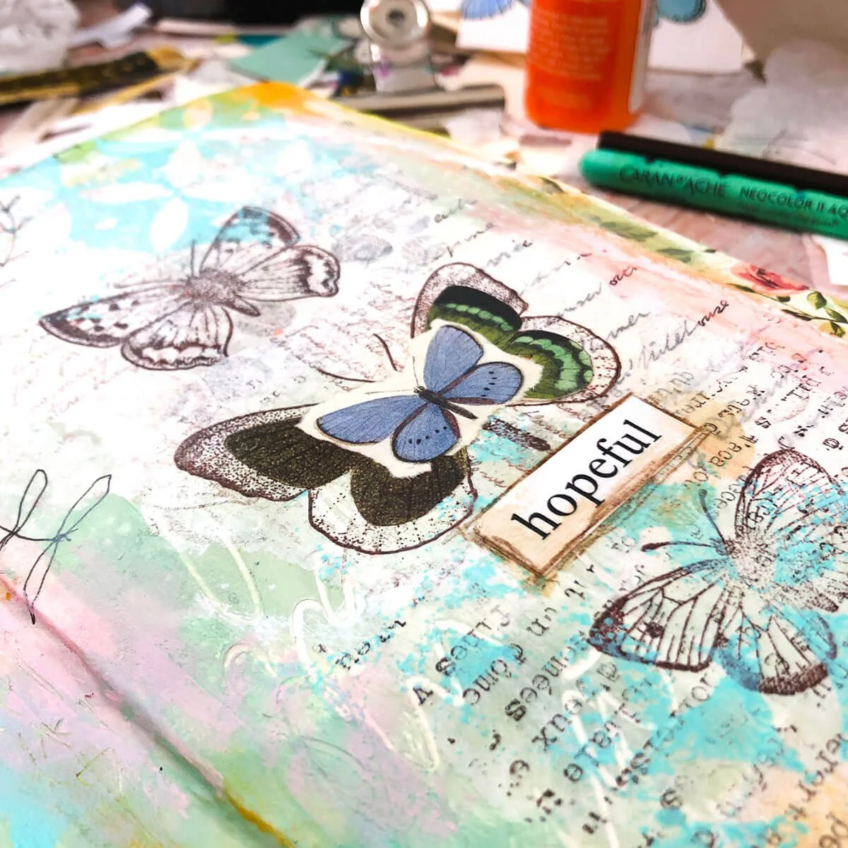 Mixed media artwork showing stamping and stencil textures layered over paint and collage.