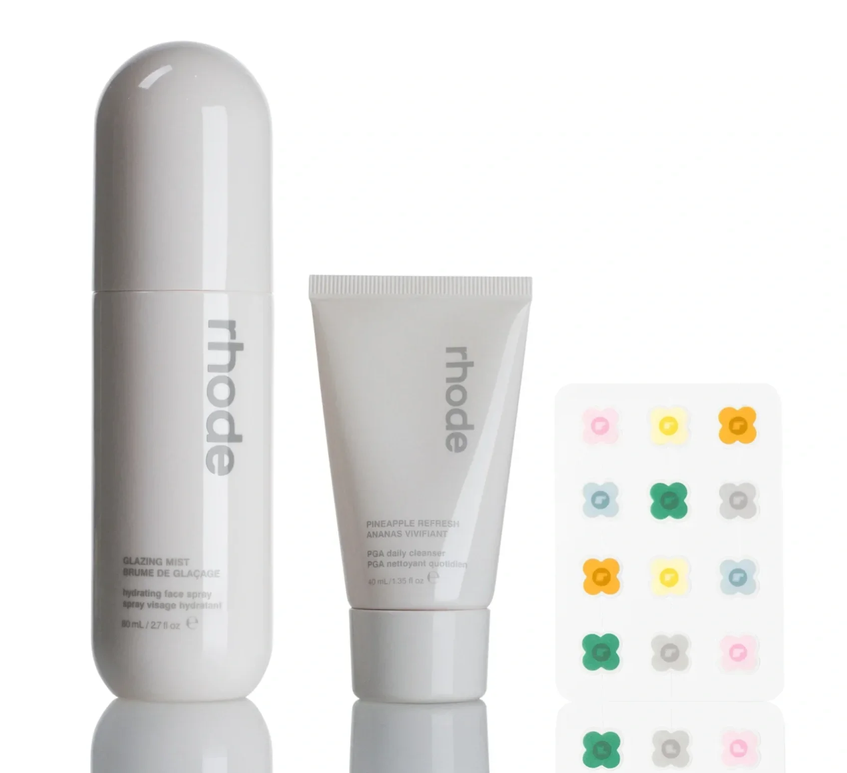 Skincare products including a white hydrating mist spray, a pineapple refresh cleanser, and a sheet of colorful flower-shaped stickers.