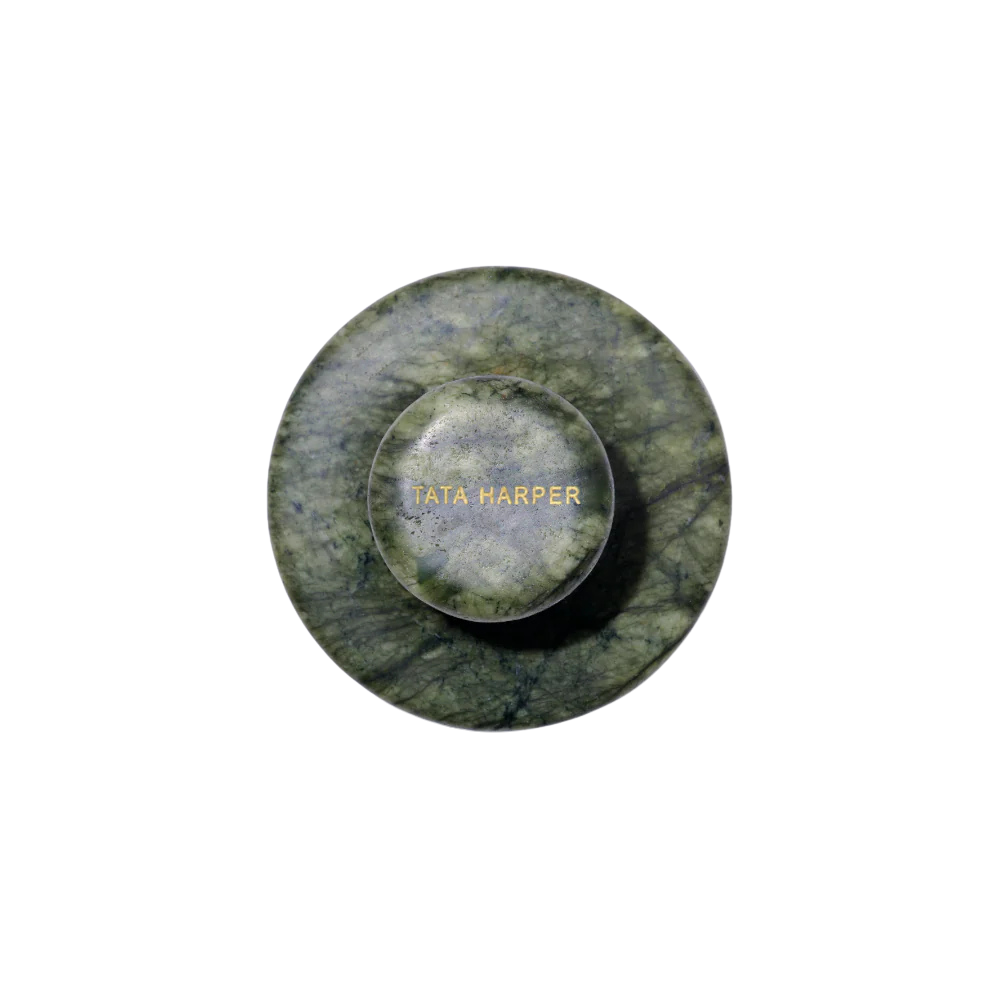 Top view of a green marble jewelry box with the name 'TATA HARPER' engraved in gold on the lid.