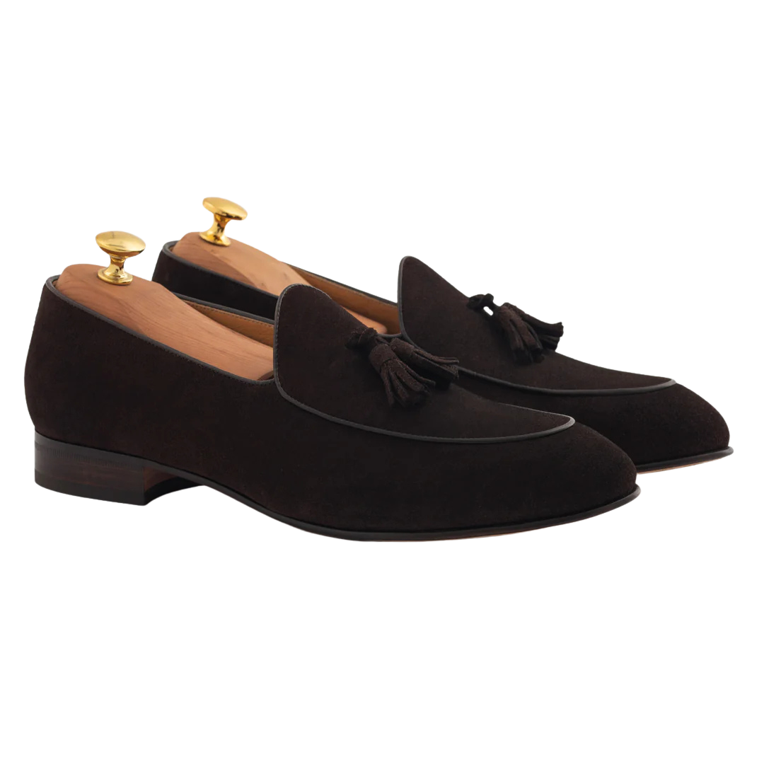 Black suede loafers with tassels and wooden shoe trees inside.