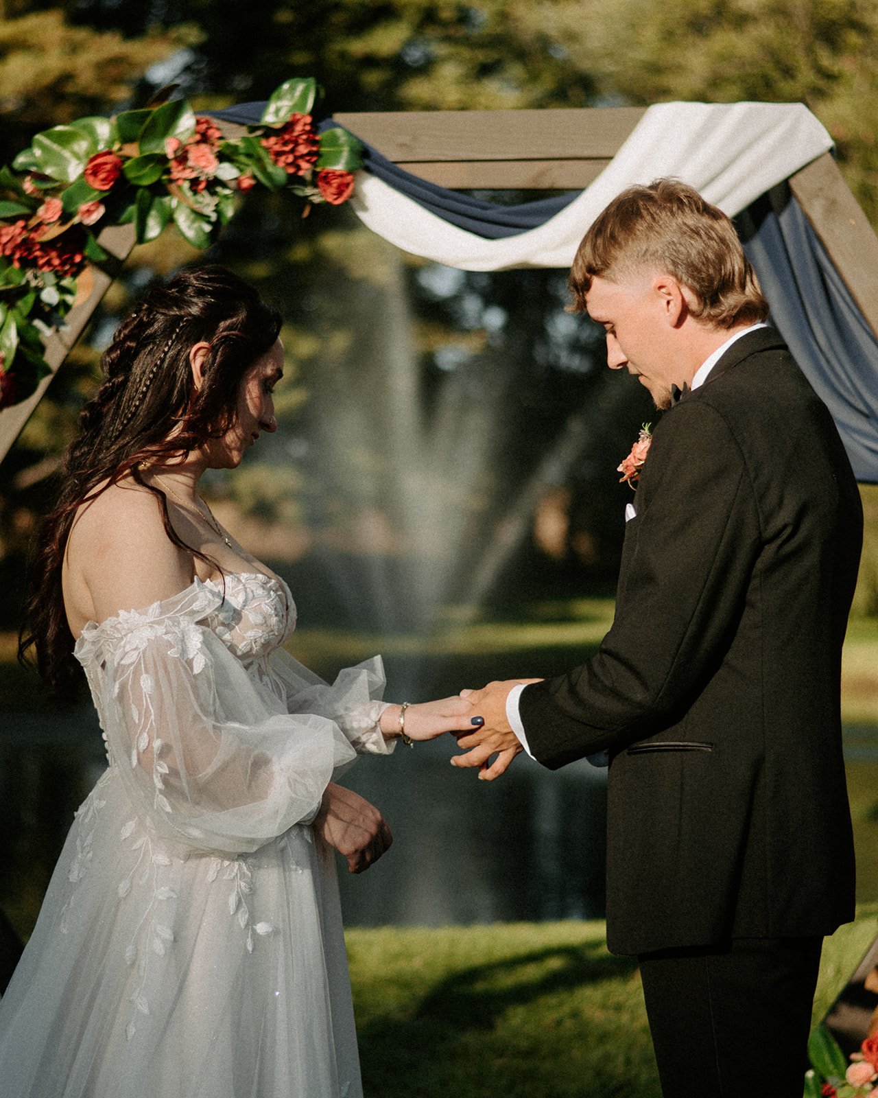 exchanging rings at outdoor ceremony with a pond
