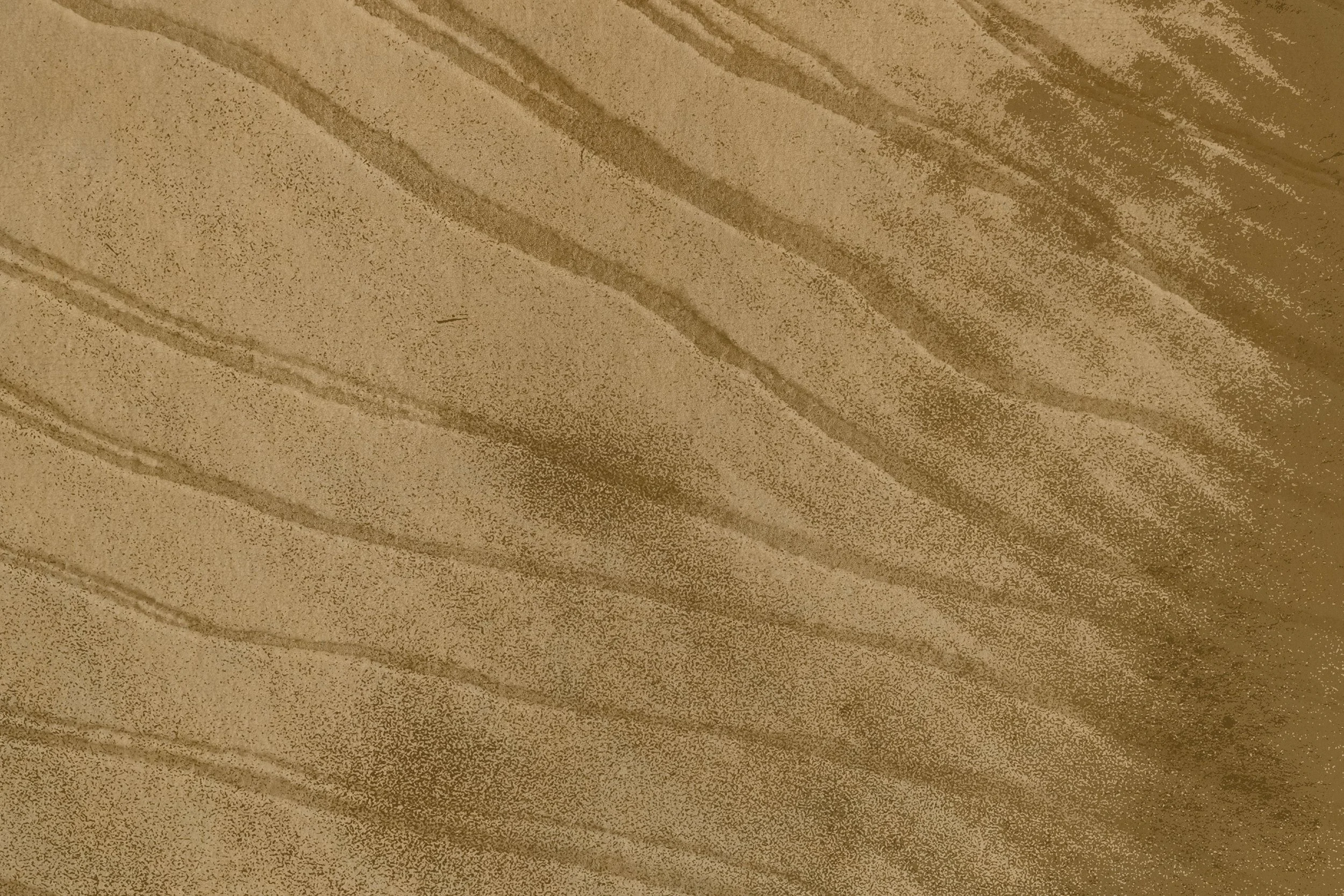 Close-up of a wooden surface with visible grain patterns and texture, in a light brown color.