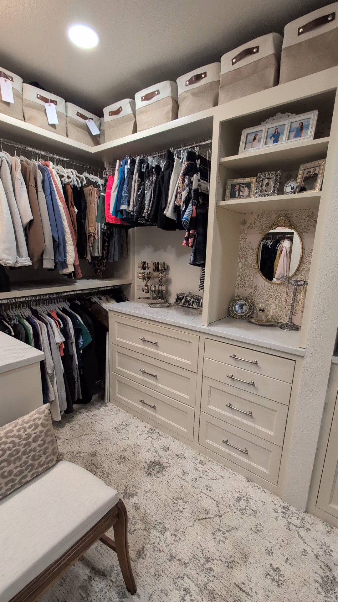 High end custom closet with inset drawers, metal hanging rods, gold metal accents